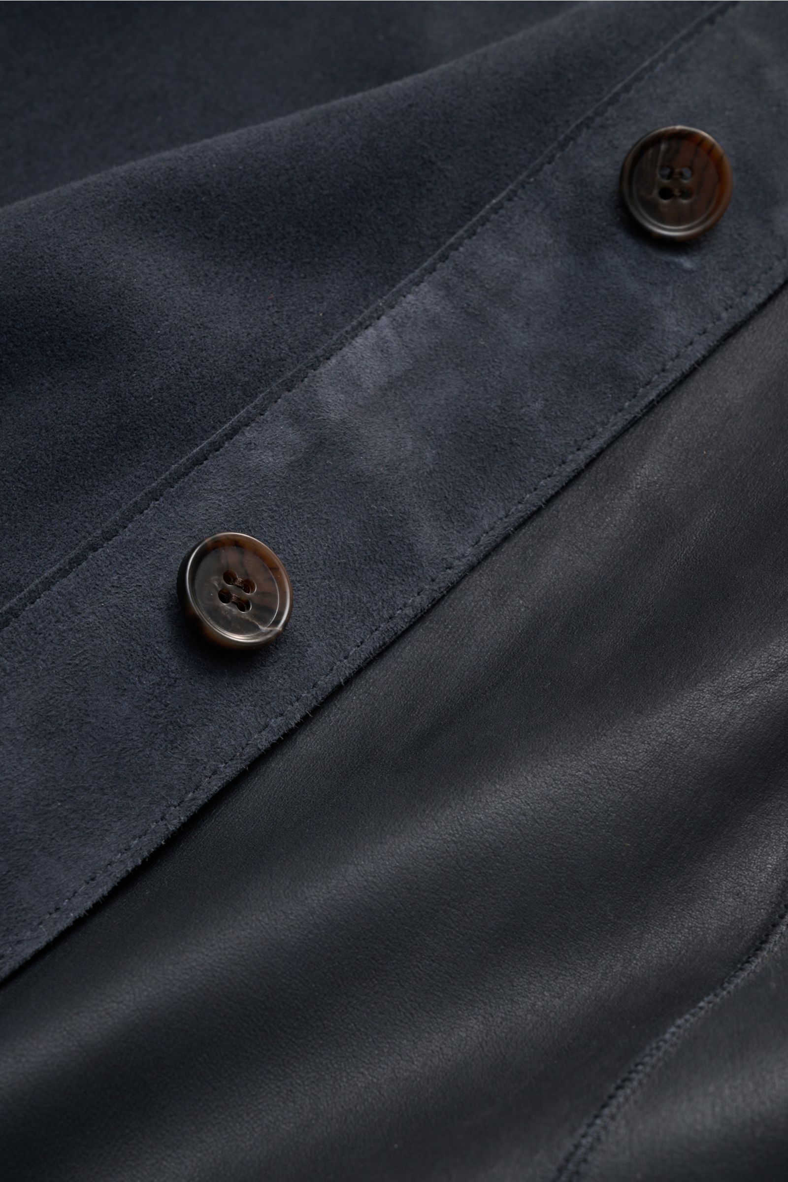 Close-up top-down view of the Arma Velourslederjacke 'Dino' navy showing soft velours leather with a smooth touch, slim fit, six-button placket, and textured button details, highlighting the unconstructed design and fine stitching. Stilvoller Begleiter fü