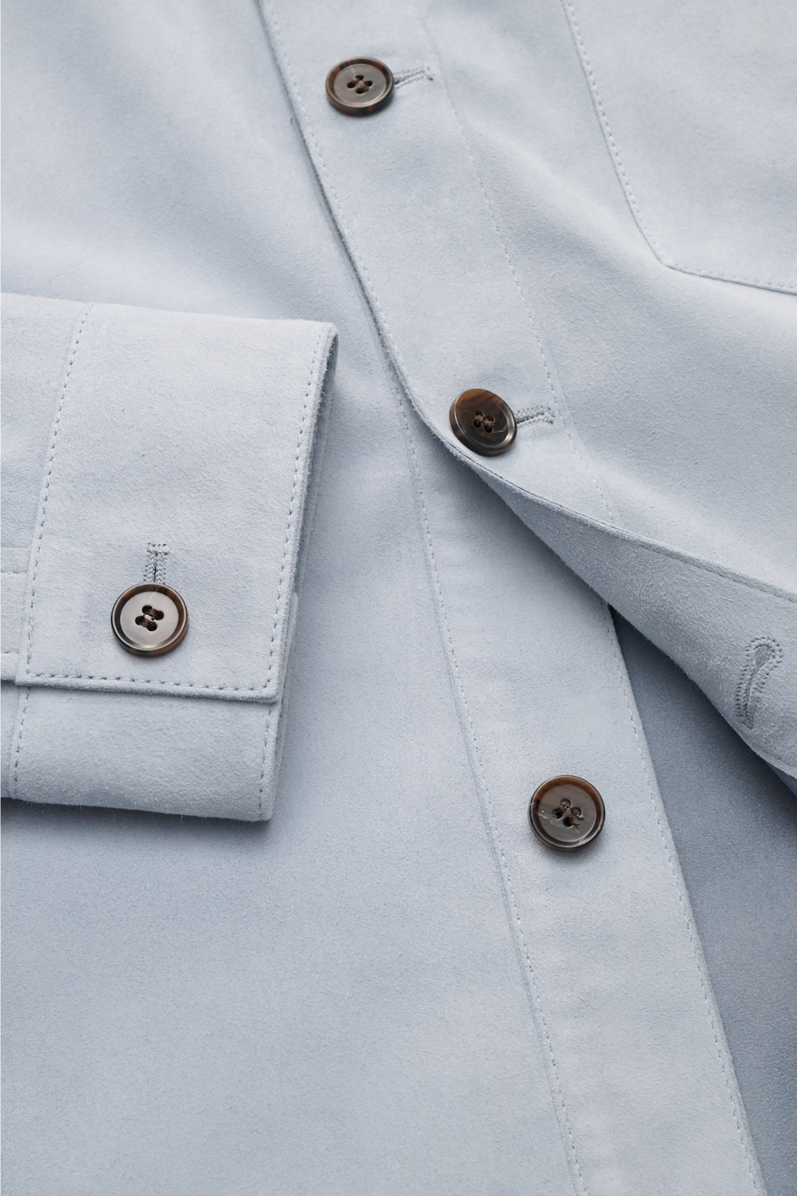 Nahaufnahme der Arma Velourslederjacke 'Dino' rauchblau von vorne, zeigt softes Veloursleder, Slim Fit, Umlegekragen, sechs Knöpfe, drei Fronttaschen, Ärmel mit Knopf, unconstructed Design.