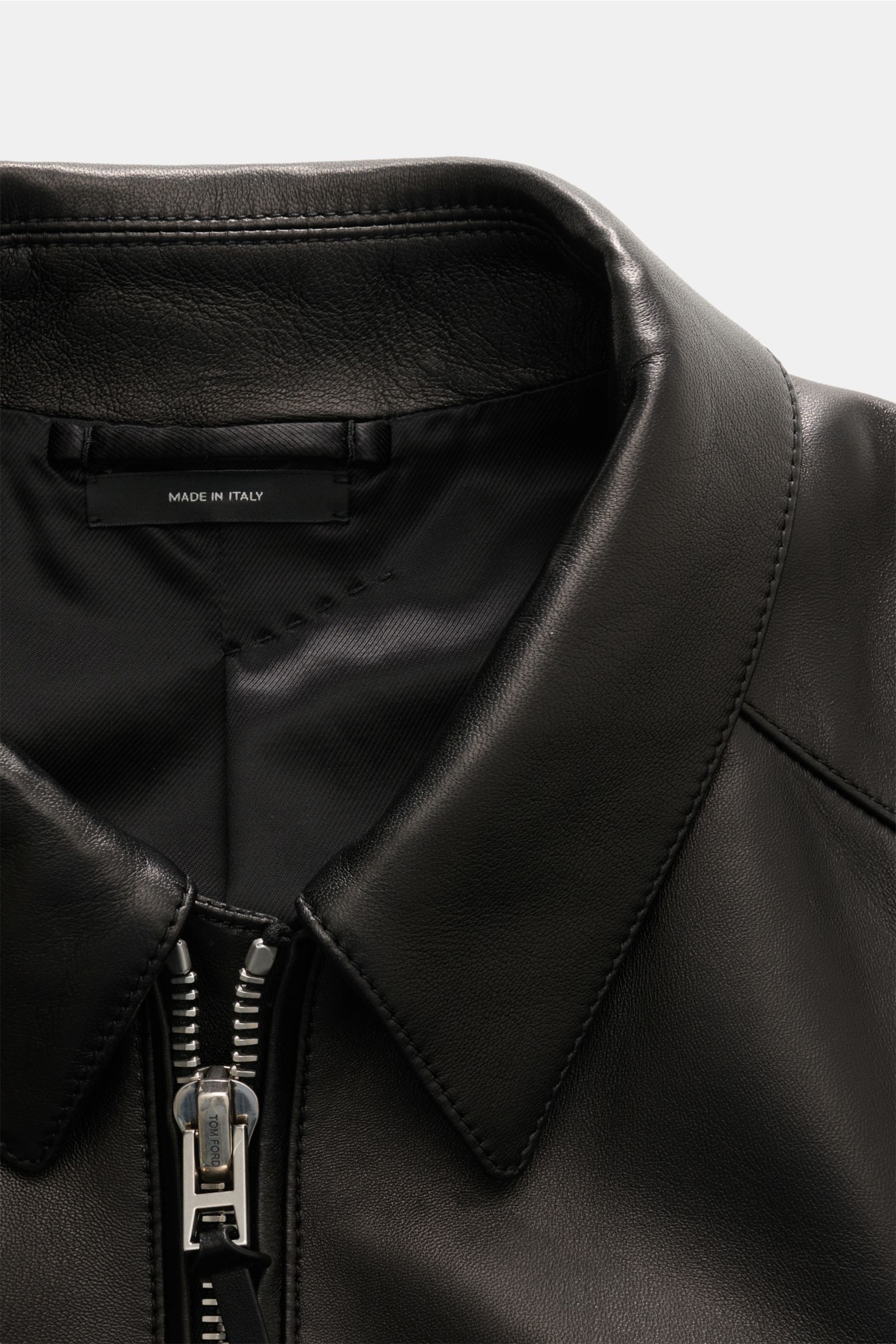 Close-up front view of the Tom Ford Lederjacke schwarz, showing the soft lamb leather collar and robust silver zipper. Luxus wie gewohnt von TOM FORD: diese Jacke aus geschmeidigem Lammleder mit Umlegekragen wurde in zeitlosem, geradlinigem Design gefe