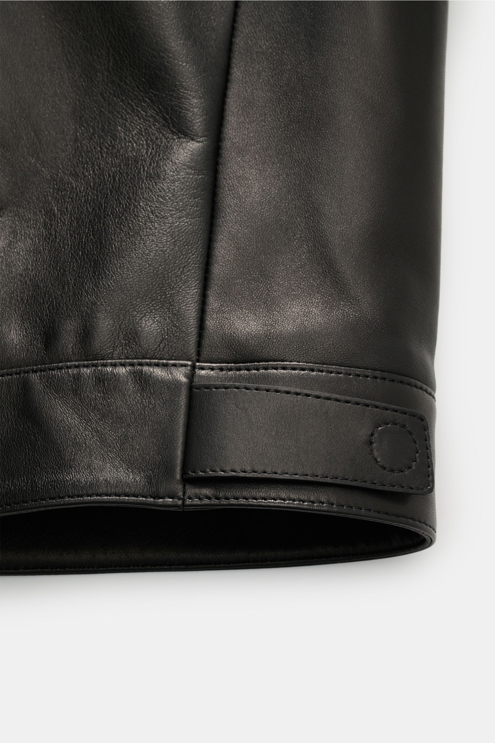Close-up view of the sleeve cuff of the Tom Ford Lederjacke schwarz, showcasing soft black lamb leather with a snap button strap and fine stitching. Luxus wie gewohnt von TOM FORD: diese Jacke aus geschmeidigem Lammleder mit Umlegekragen wurde in zeitl