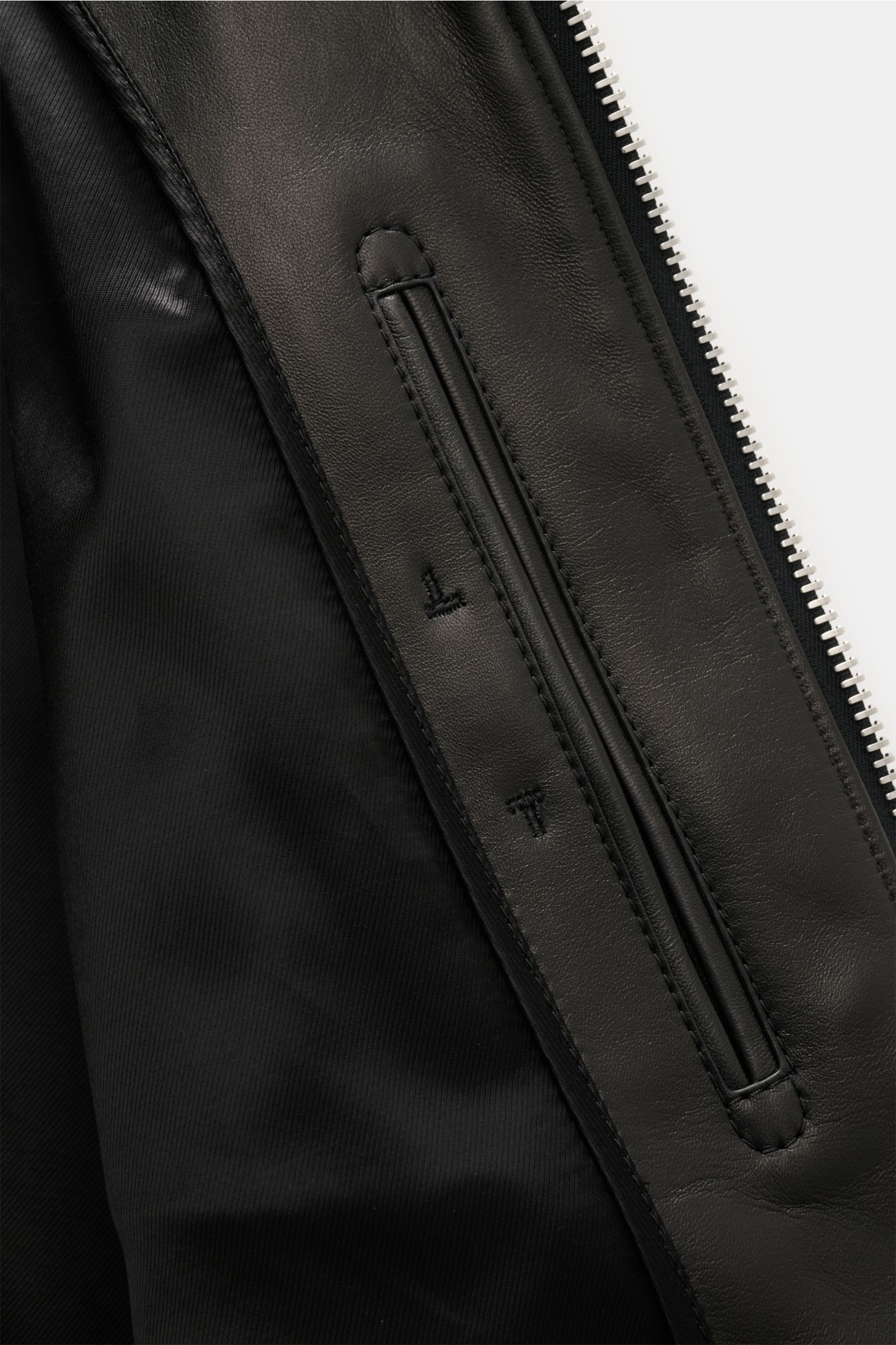 Close-up front interior view of Tom Ford Lederjacke schwarz showing smooth lamb leather, soft lining, and robust zipper detail.

Luxus wie gewohnt von TOM FORD: diese Jacke aus geschmeidigem Lammleder mit Umlegekragen wurde in zeitlosem, geradlinigem D