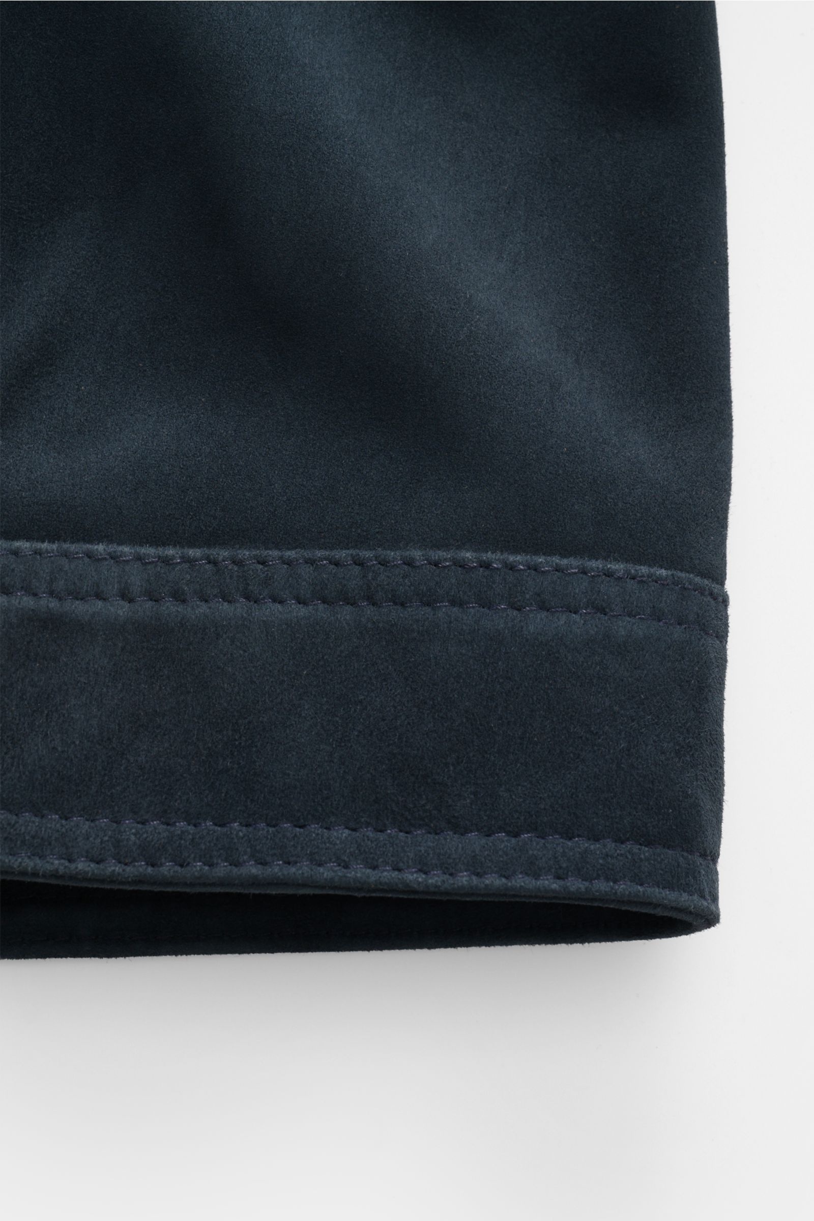 Close-up of the sleeve hem of the Officine Générale Velourslederjacke 'Loki' graublau, showing fine stitching on smooth grey-blue goat suede from a side angle.