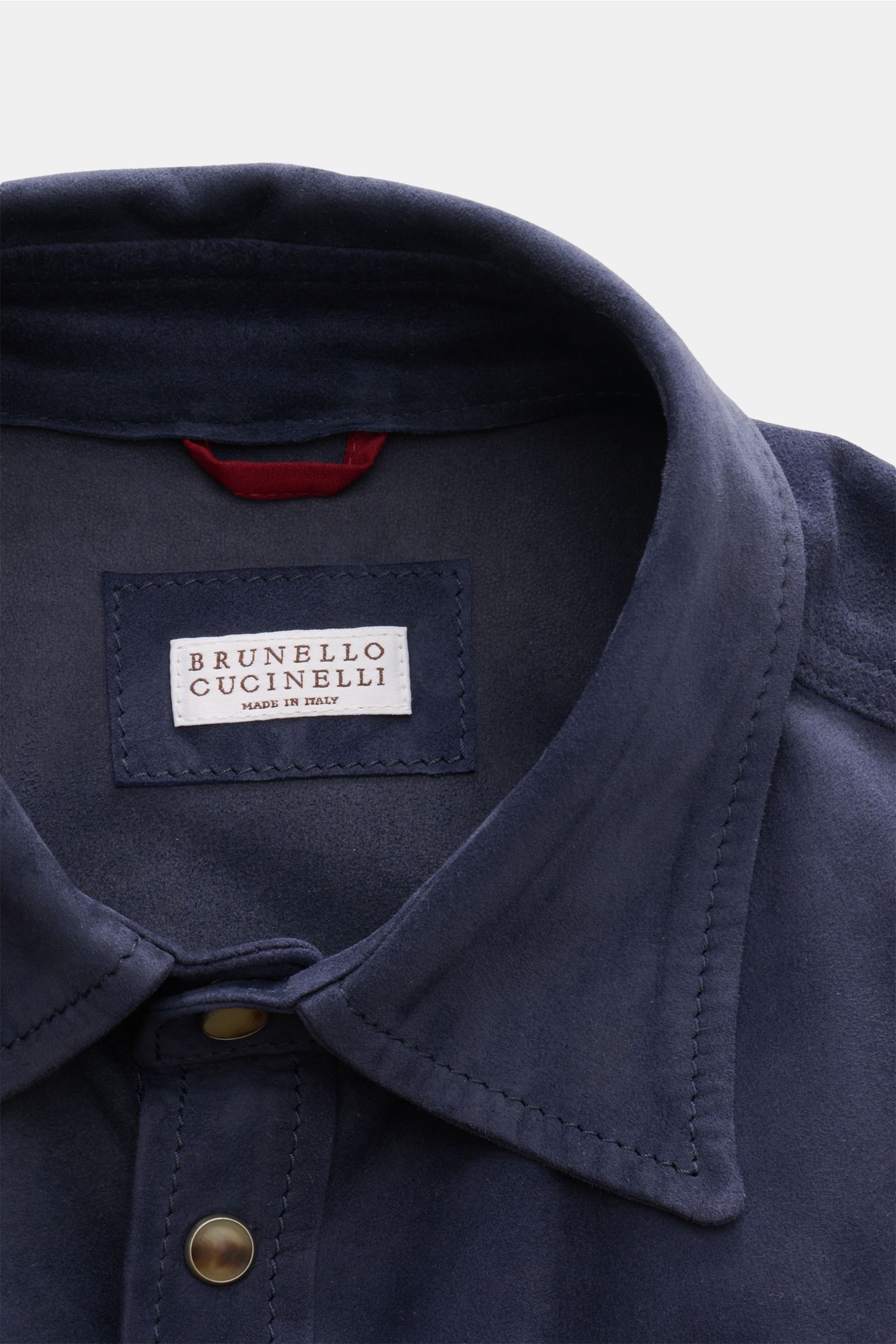 Close-up front view of the Brunello Cucinelli Veloursleder-Overshirt navy, showcasing smooth velour leather, soft touch, slim fit, seven-button placket, spread collar, chest pocket, cuffed sleeves, and unconstructed design, highlighting souveräne Frühling