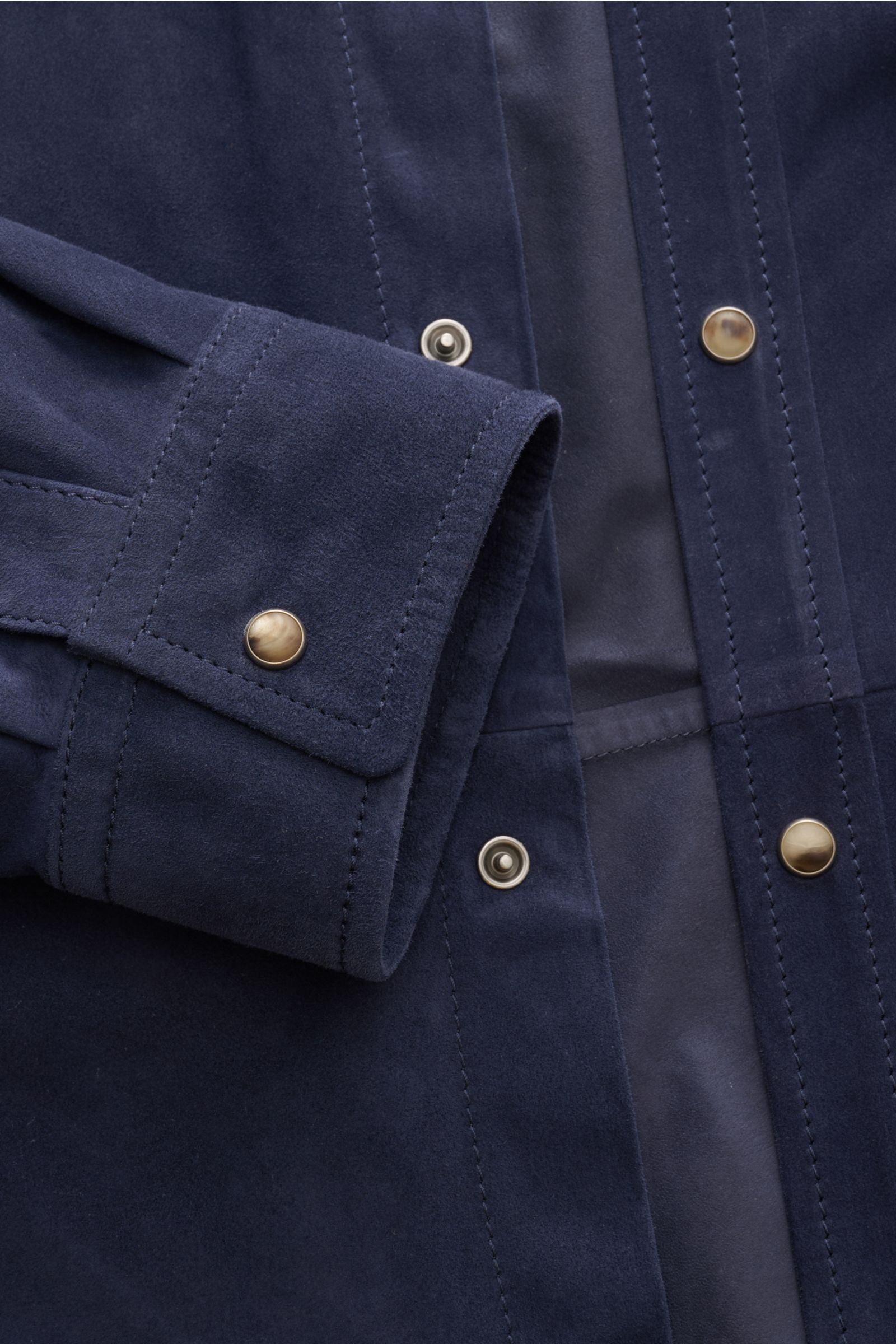 Close-up front view of Brunello Cucinelli Veloursleder-Overshirt navy in smooth velour leather with slim fit, seven-button placket, cuffed sleeves, chest pocket, and unconstructed design, showcasing soft texture and luxurious materiality. Souveräne Frühli