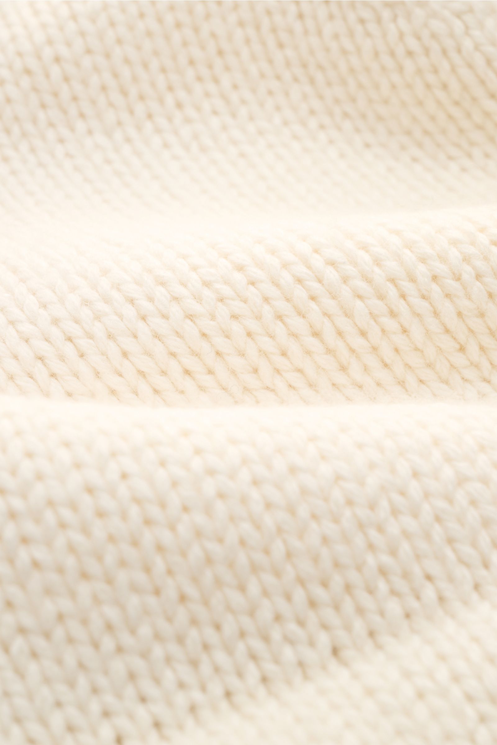Nahaufnahme des feinen, mittelfeinen Strickbilds des 04651/ A trip in a bag Cardigan 'Boiled Blouson' offwhite aus Woll-Mix.