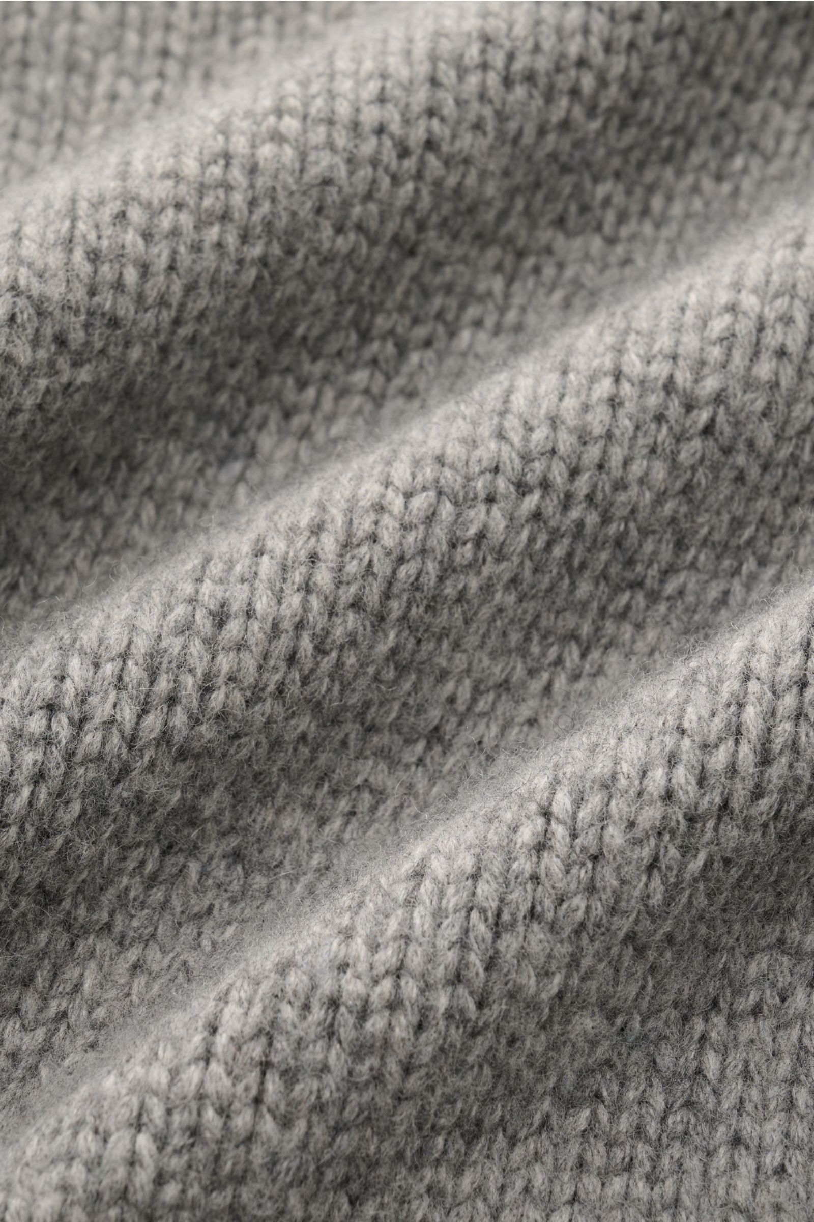 Graue Nahaufnahme des dichten, mittelfeinen Strickbilds des 04651/ A trip in a bag Cardigan 'Boiled Blouson' aus Woll-Mix.