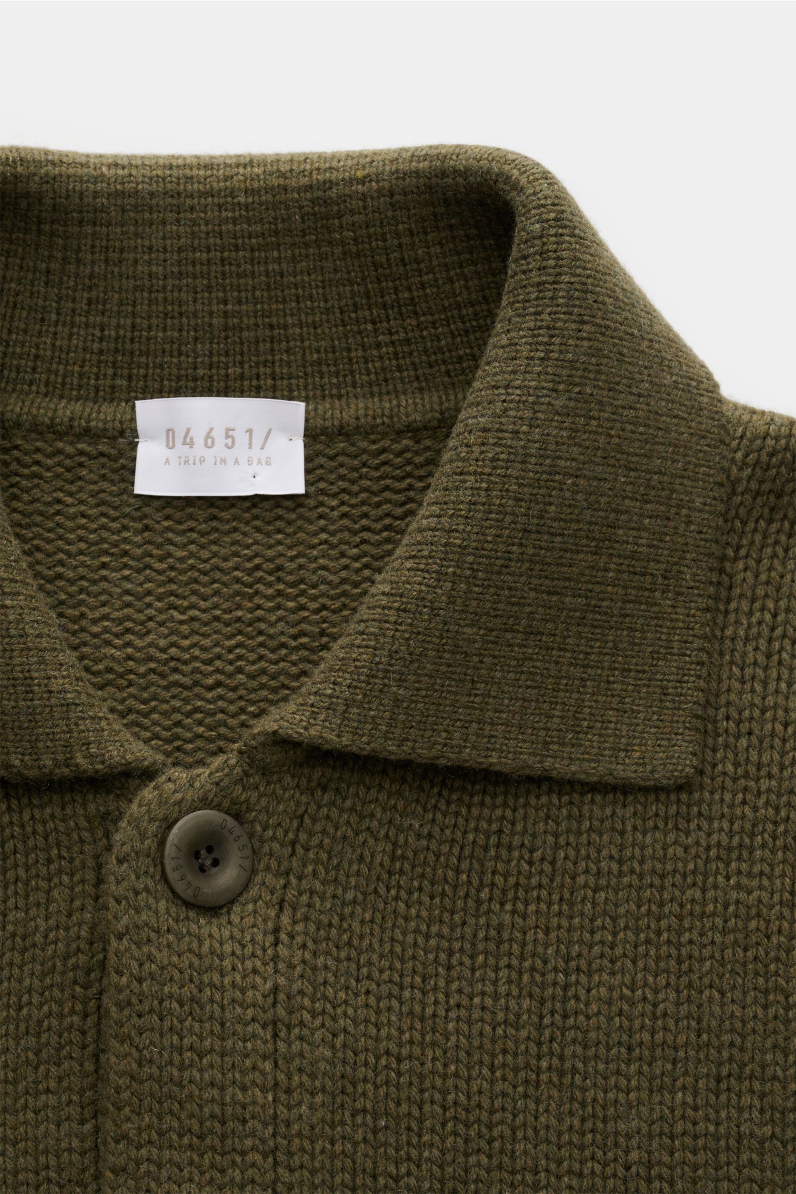 Close-up front view of the 04651/ A trip in a bag Cardigan 'Boiled Blouson' olive, showcasing chunky knit, turn-down collar, and six-button placket.

The cardigan 'Boiled Blouson' made of a premium wool blend by label 04561 / A TRIP IN A BAG is a must-