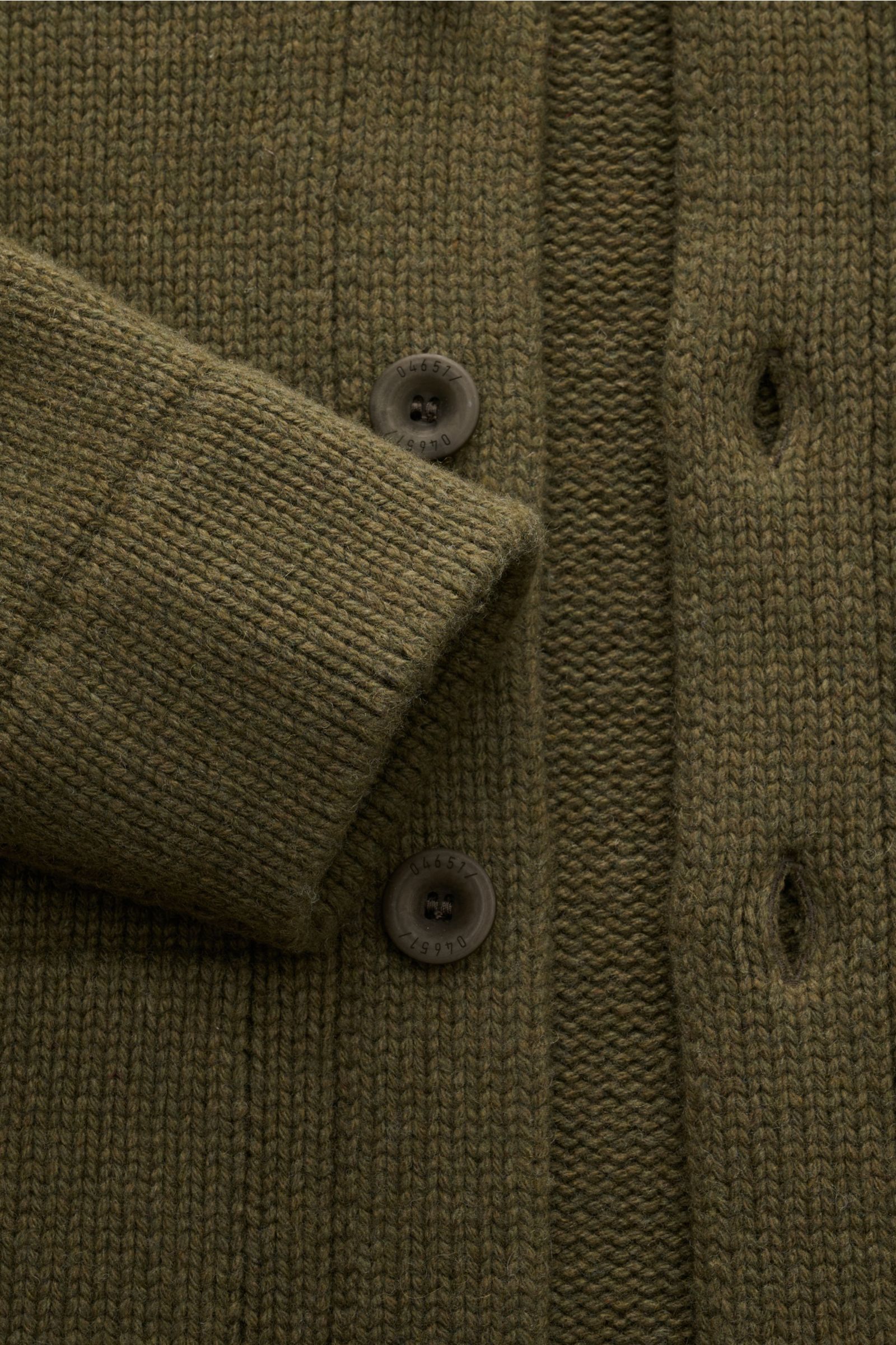 Close-up front view of the 04651/ A trip in a bag Cardigan 'Boiled Blouson' olive showing chunky knit wool blend fabric, six-button placket, and ribbed cuff. The cardigan 'Boiled Blouson' made of a premium wool blend by label 04561 / A TRIP IN A BAG is a 