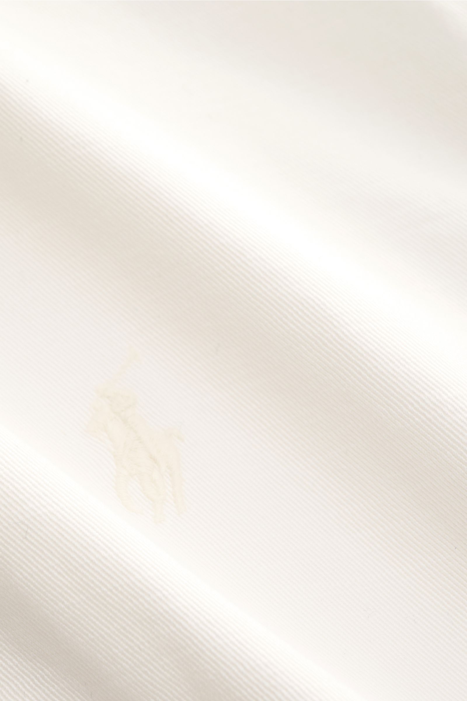 Polo Ralph Lauren Blouson weiß, leichter Baumwolltwill, Slim Fit, robuster Reißverschluss, Stehkragen mit Knöpfen, Brust-Polo-Reiter-Stitching, schräge Taschen, flexible Bündchen, Detailfoto aus Nahaufnahme.