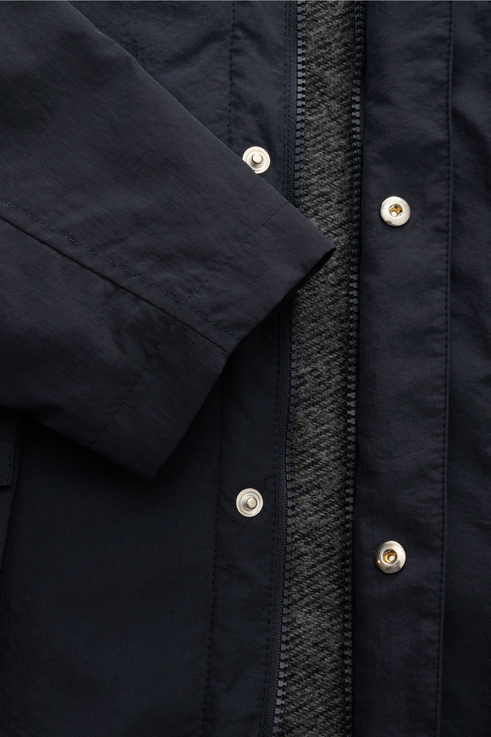 Close-up front view of the 04651/ A trip in a bag Parka 'The Triple' navy, showing lightweight microfibre fabric, zip, snap buttons, and textured detachable gilet lining. Lightweight and sporty for the transitional period: This versatile parka with detach