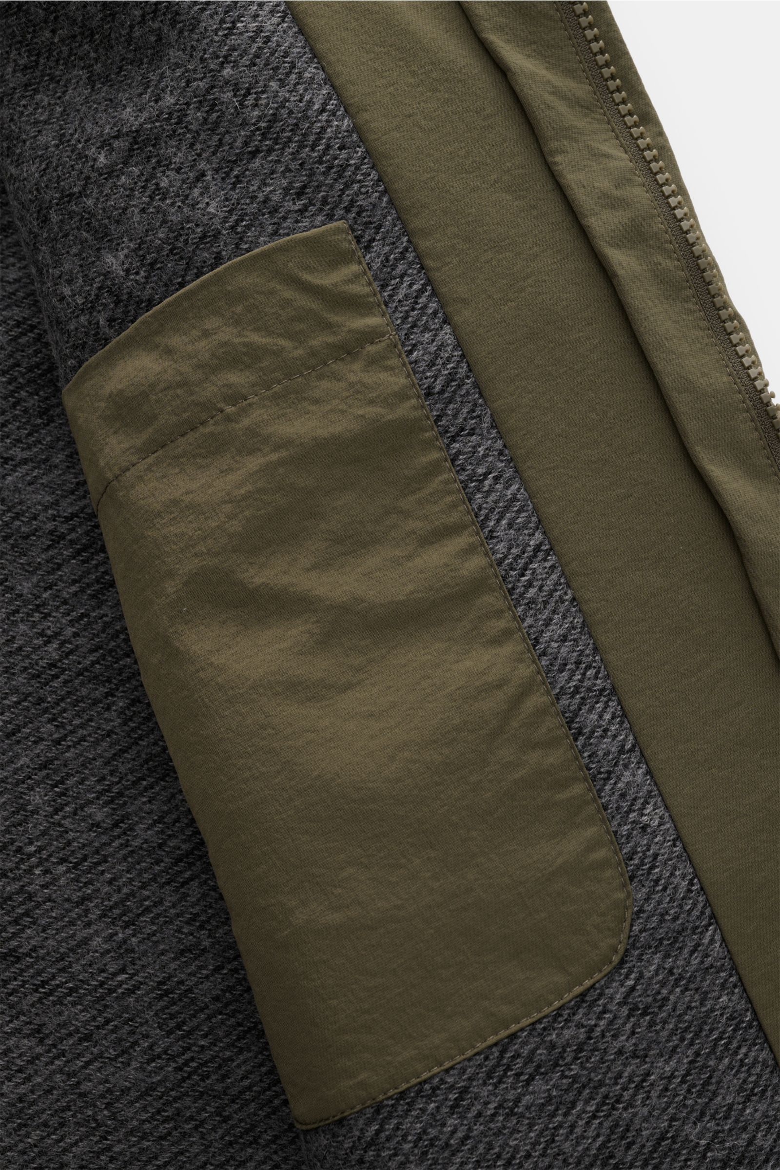 Close-up interior view of the 04651/ A trip in a bag Parka 'The Triple' oliv showing the olive removable vest pocket, high-quality microfiber, and contrast grey lining texture. Sportlich-leger durch die Übergangszeit: Der vielseitige Parka mit herausnehmb