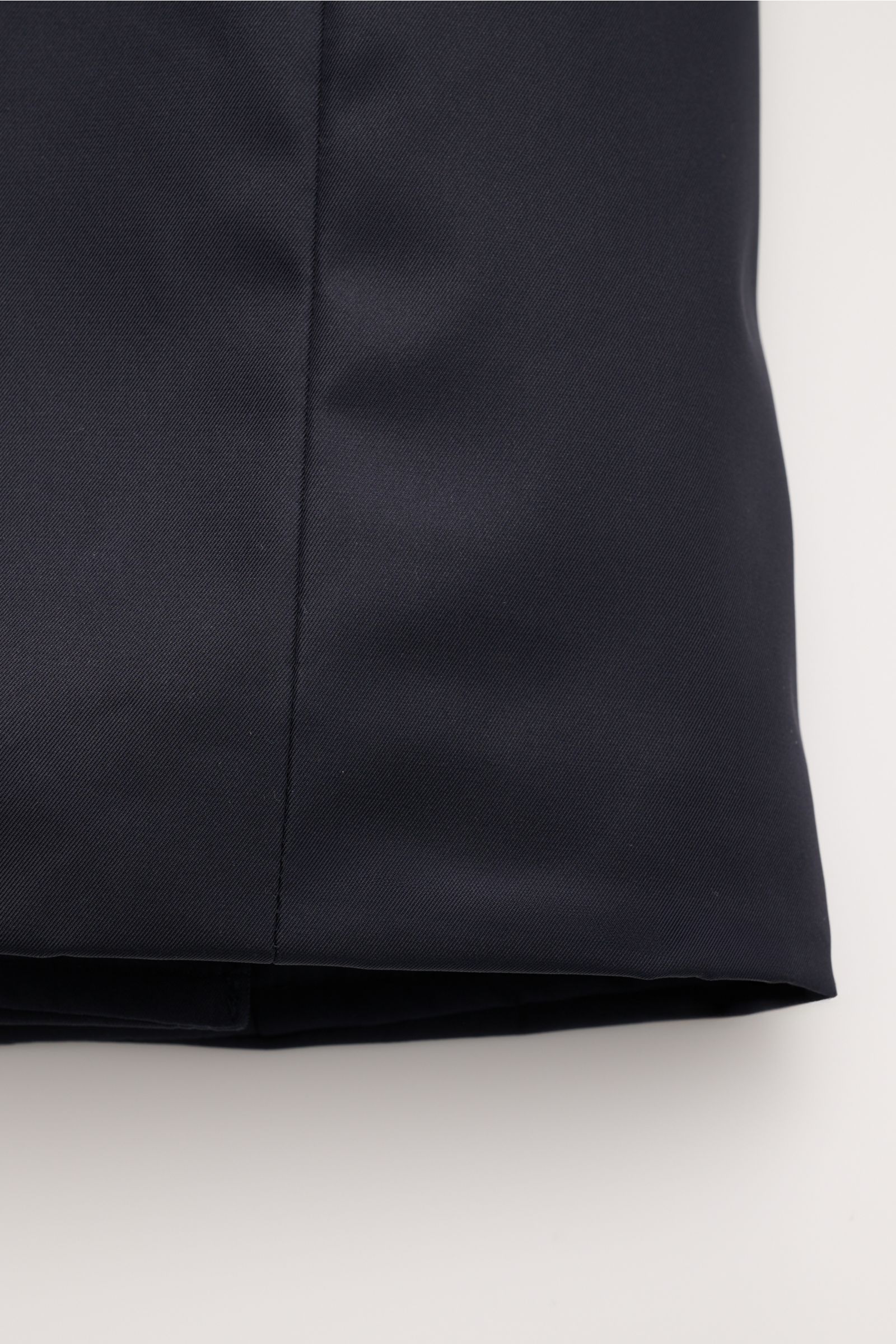Close-up image of the lower section of the Moorer Daunenjacke 'Bolgi' navy, showing the smooth gabardine fabric with a silky sheen and central seam, photographed from the front at hem level. Eleganz trifft Funktion: Gefertigt aus edlem Gabardine mit seidi