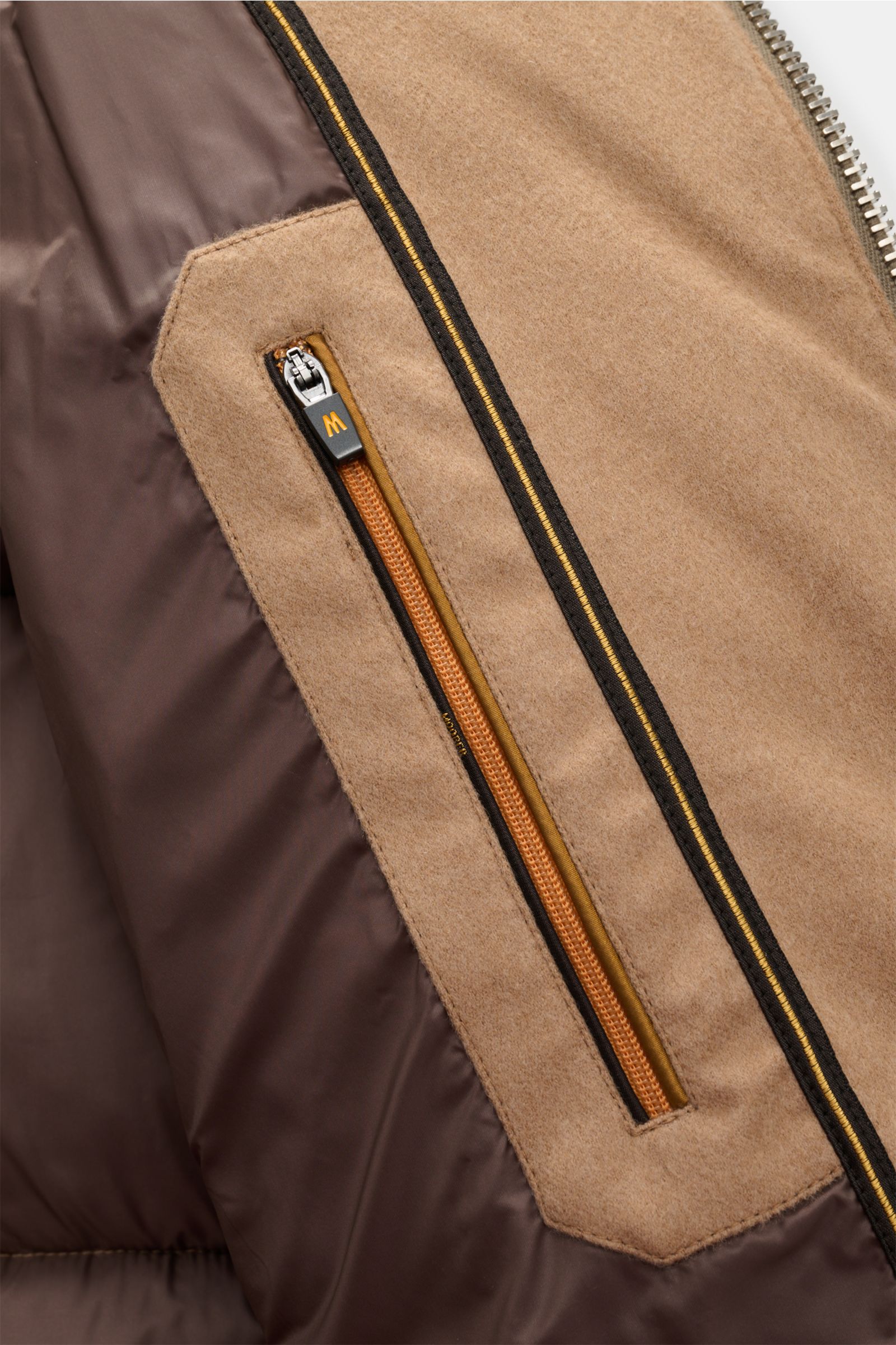 Innenansicht der Moorer Daunenjacke 'Valls' camel mit weichem Kamelhaar, wattierter Kapuze, zwei Innentaschen und zwei-Wege-Reißverschluss.