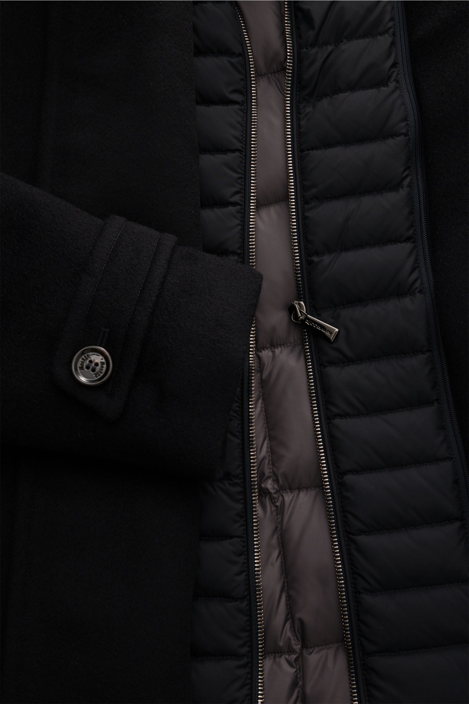 Close-up front view of Moorer Jacke 'Volmer-Kn' navy showing double-front zippers, buttoned sleeve cuff, and quilted inner lining. Die 'Volmer-Kn' von MOORER vereint stilvolle Eleganz mit praktischer Funktionalität. Im Cabanjacken-Stil gehalten und was