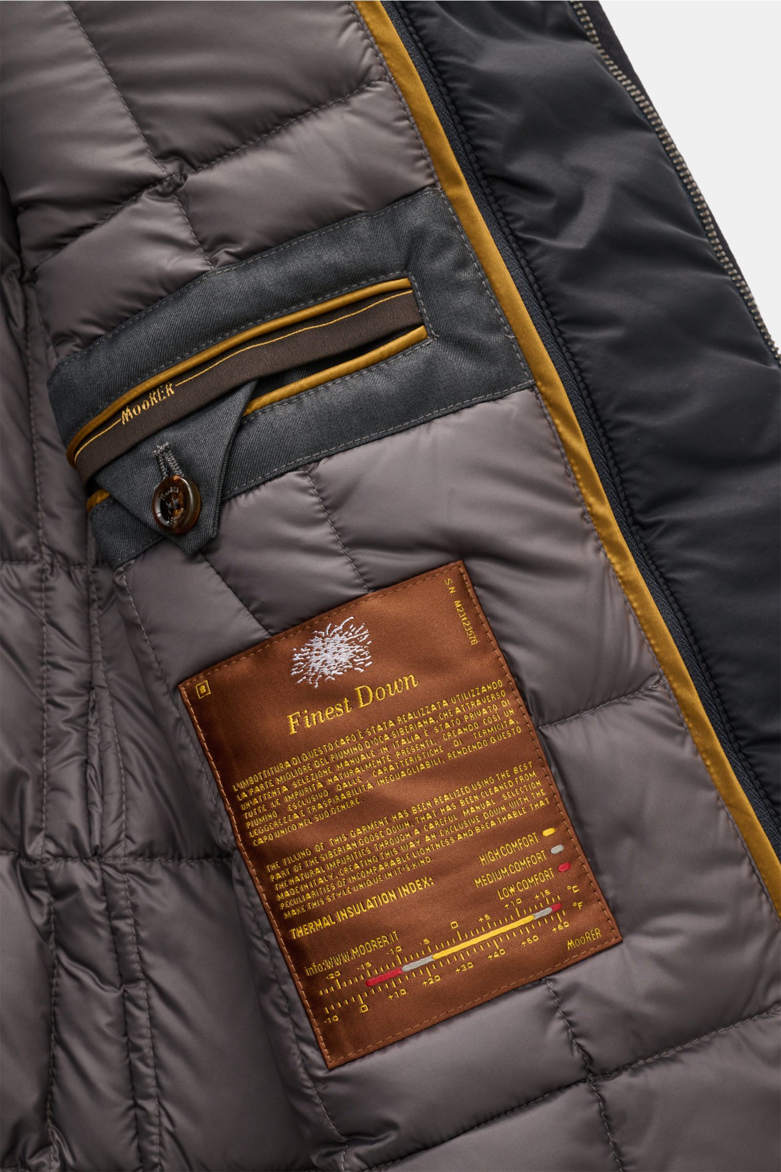 Close-up inside view of the Moorer Jacke 'Volmer-Kn' navy, showing the Finest Down label and inner pocket details.

Die 'Volmer-Kn' von MOORER vereint stilvolle Eleganz mit praktischer Funktionalität. Im Cabanjacken-Stil gehalten und wasserabweisend, b