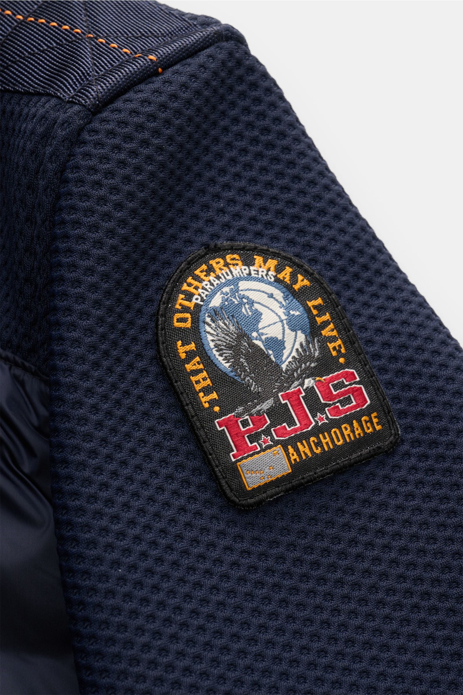Close-up side view of the Parajumpers Daunenjacke 'Jayden' navy sleeve, showcasing the mesh fabric, high-quality microfiber, and the distinctive PJS Anchorage patch with a smooth touch, wind-resistant, slim fit, light down filling in chest and back, mesh 