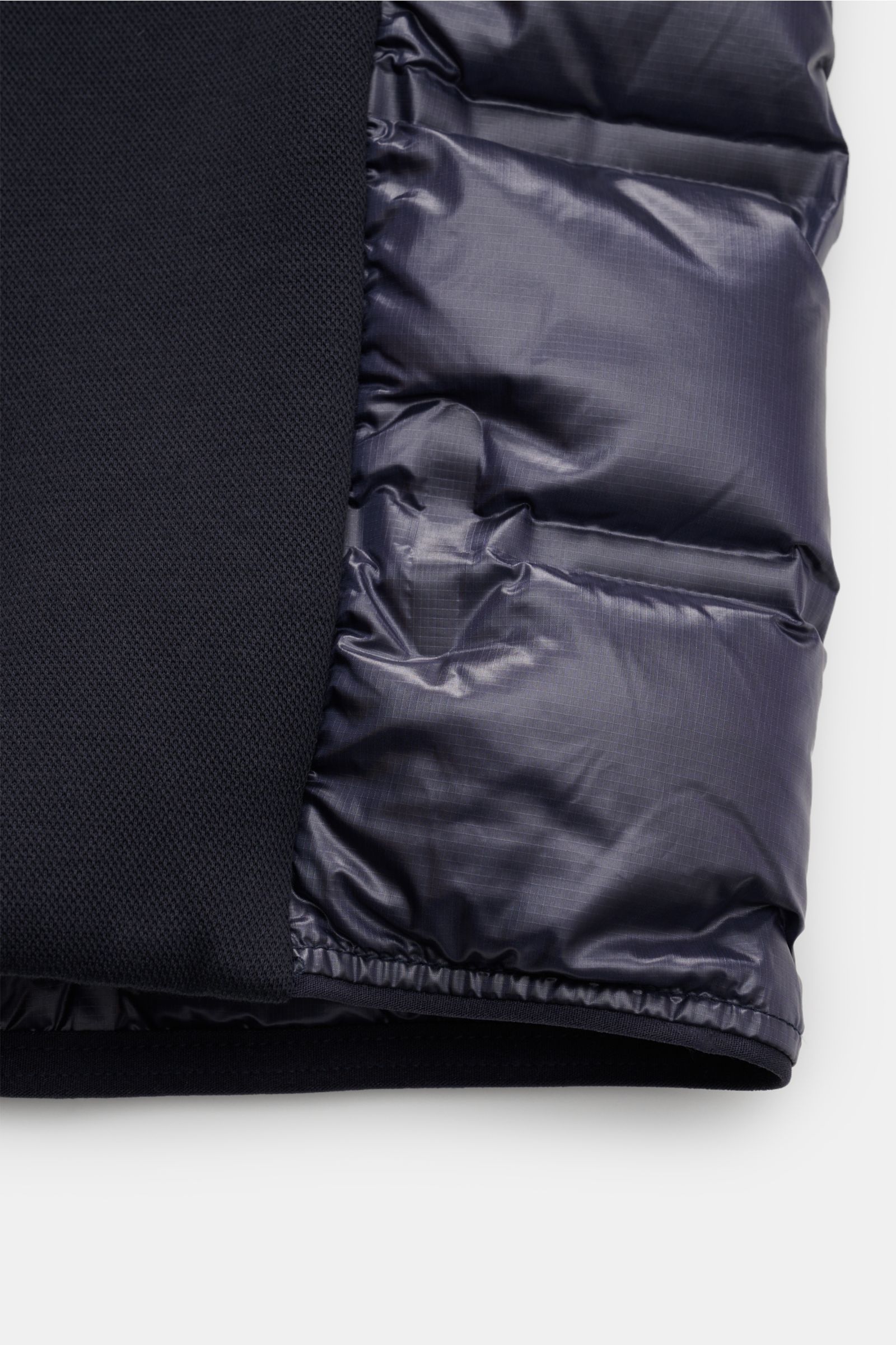 Close-up front view of the Parajumpers Daunenjacke 'Gyles' navy showing the glossy ripstop microfiber puffer fabric with quilted design and robust jersey details. Für einen sportiven und stylishen Look in der Übergangszeit sorgt die teils gesteppte Jacke 