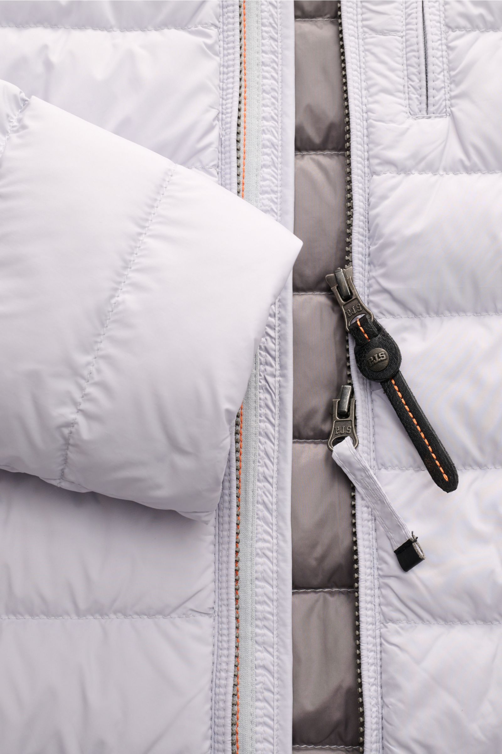 Close-up front view of Parajumpers Daunenjacke 'Ugo' hellgrau showing light grey microfiber fabric, dual zipper with branded pull tabs, and padded sections; Lässiges Design und ein klares Statement für Nachhaltigkeit: Die Jacke 'Ugo' von PARAJUMPERS so