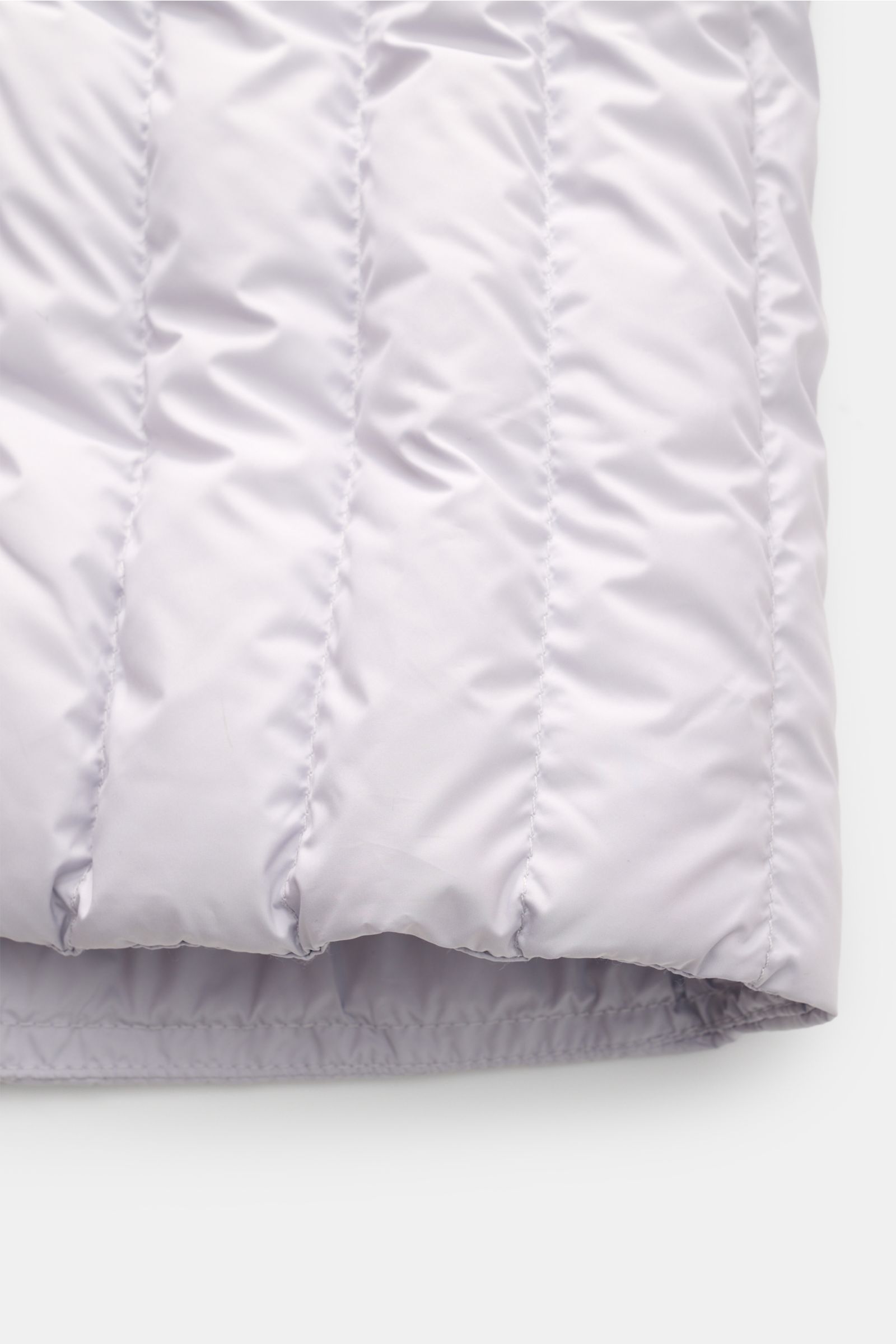 Close-up front view of the lower section of the Parajumpers Daunenjacke 'Ugo' hellgrau, showcasing its light grey quilted microfiber fabric with slim fit, elastic hem, and Super Light Weight down filling. Lässiges Design und ein klares Statement für Na