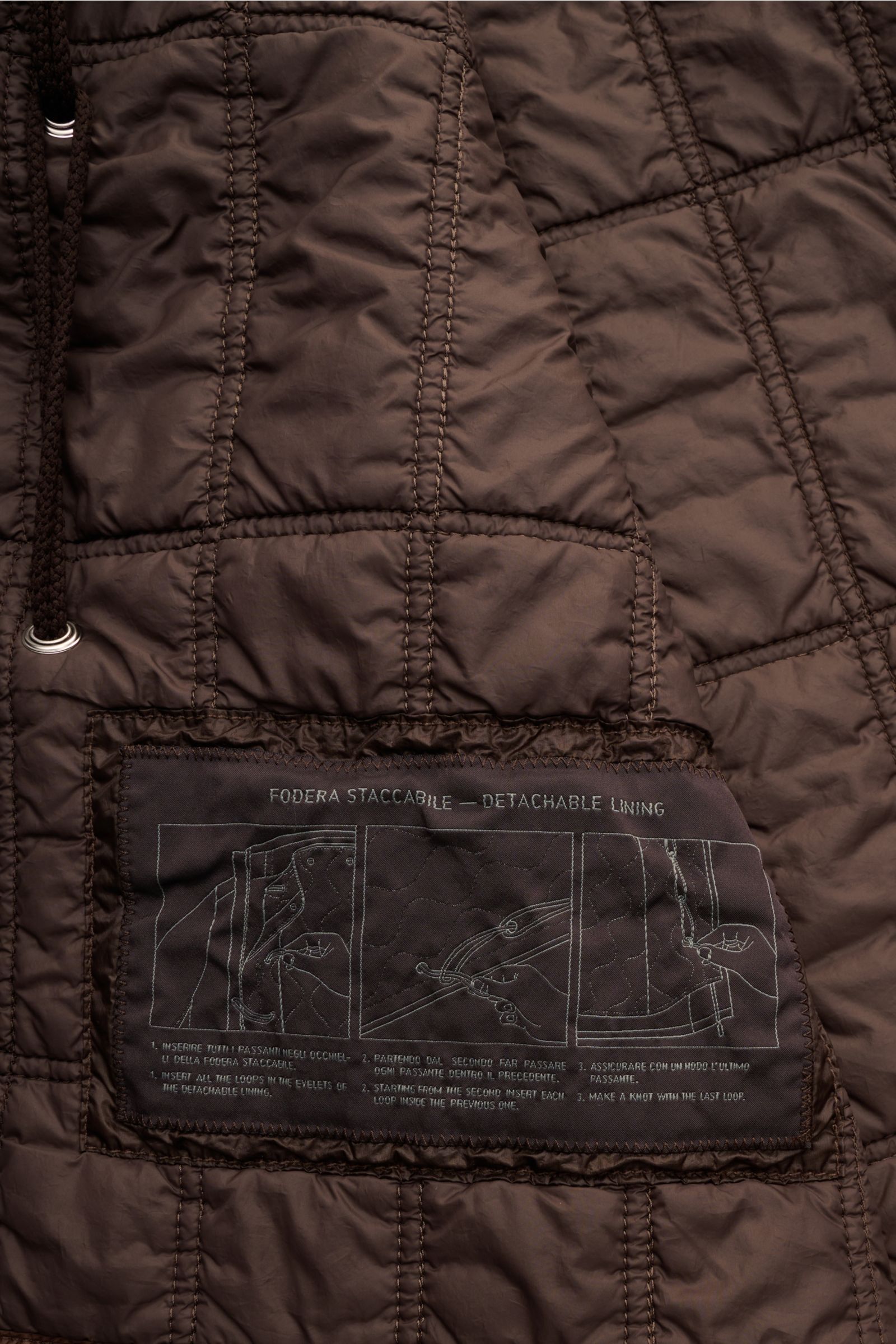 Nahaufnahme des dunkelbraunen Innenfutters mit Etikett des Stone Island Parka 'Twill Wool-TC Ghost Piece', herausnehmbar und mit veganer Primaloft-Füllung.