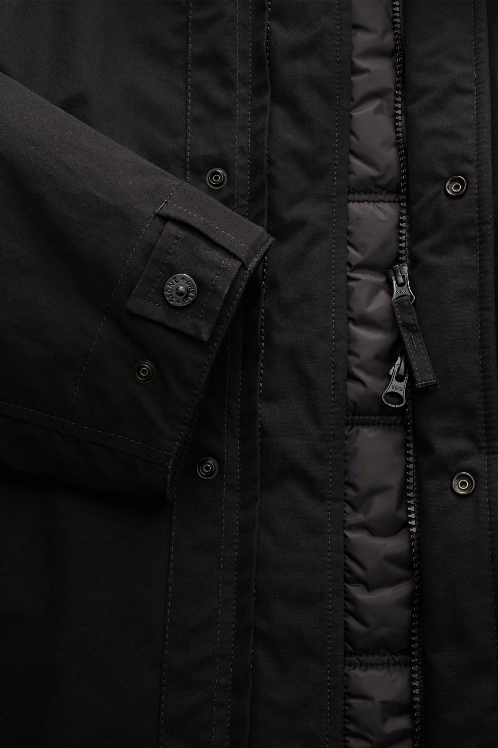 Stone Island Jacke 'Weatherproof Cotton Canvas Ghost Piece' schwarz, Detailaufnahme von innen und Ärmelsaum mit Knopf, wind- und wasserabweisend.