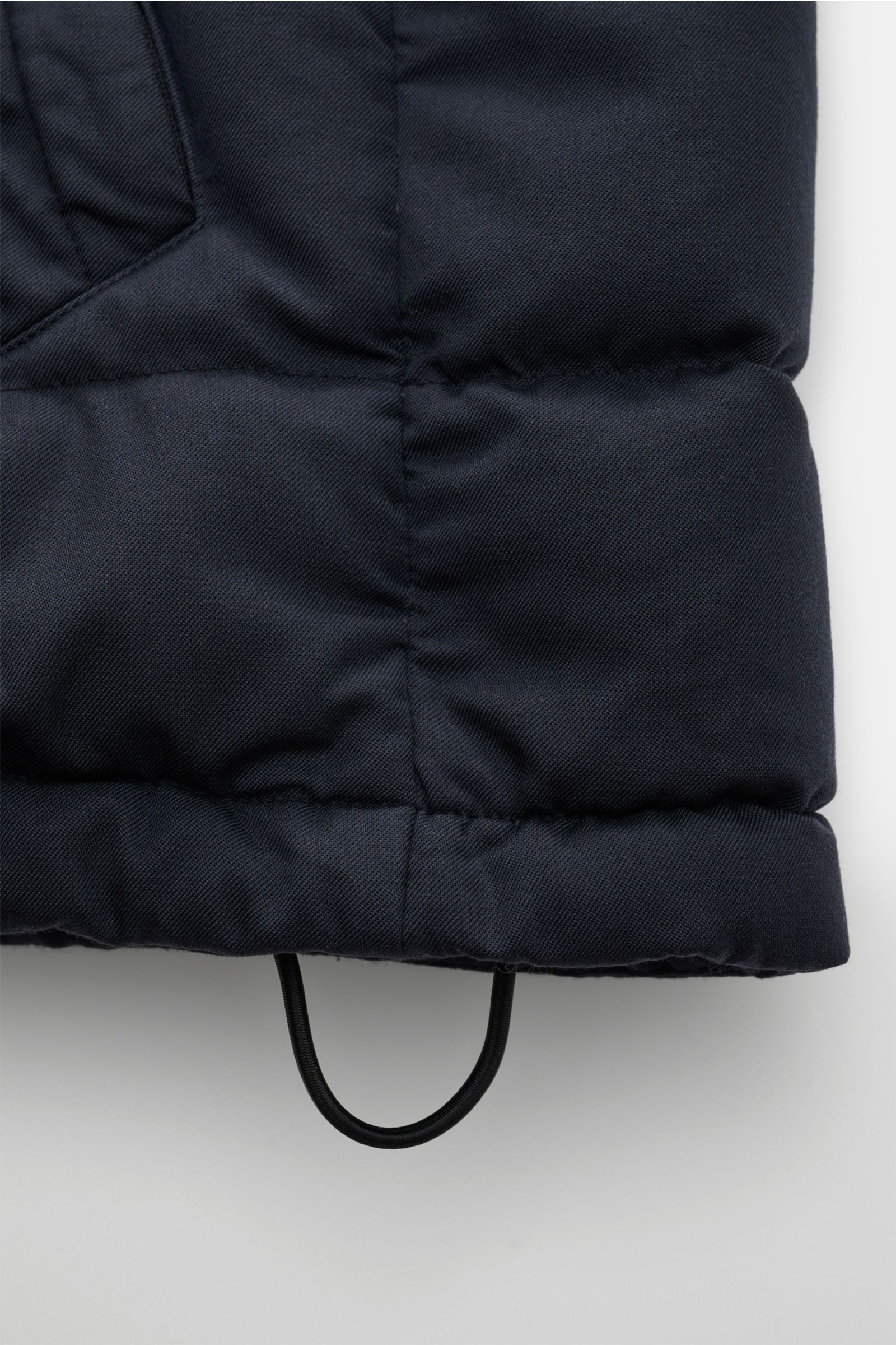 Close-up front view of the hem of the Stone Island Daunenjacke 'Twill Wool-TC Ghost Piece' navy, showing padded twill wool fabric and adjustable drawstring.

Description:  
Monochromes Statement-Piece für die Übergangszeit: Die Daunenjacke aus der 'Gho