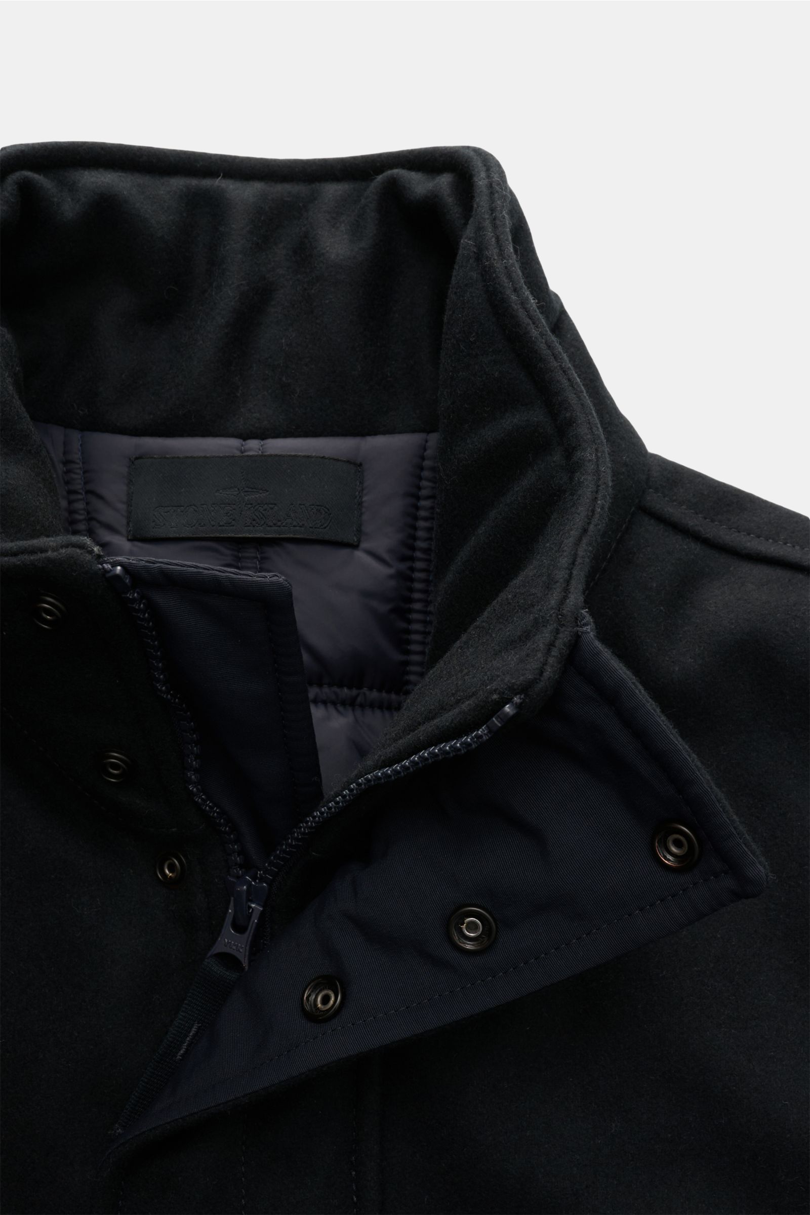 Close-up front view of Stone Island Jacke 'Wool Nylon Flannel Ghost Piece' navy, showing collar, two-way zipper, snap buttons, and quilted lining, made from water-repellent carded wool and nylon flannel, slim fit with tonal compass badge and adjustable wa
