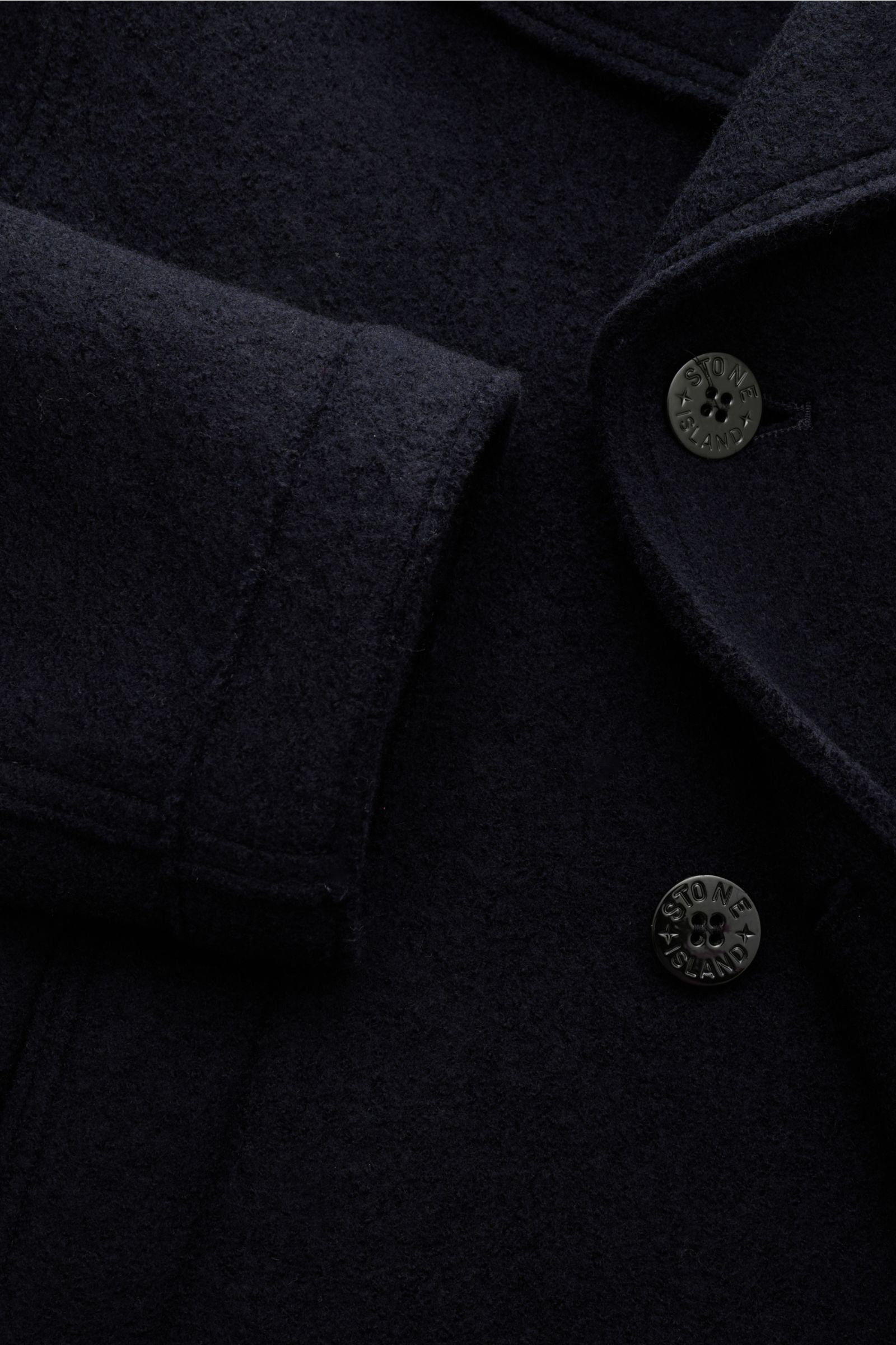 Stone Island Cabanjacke navy aus reiner, gefilzter Wolle, weicher Griff, garment dyed, zweireihige Drei-Knopf-Leiste, variabler Kragen mit Knopfriegel, schräge Leistentaschen, Kompass-Badge am Ärmel, Detailaufnahme von oben.