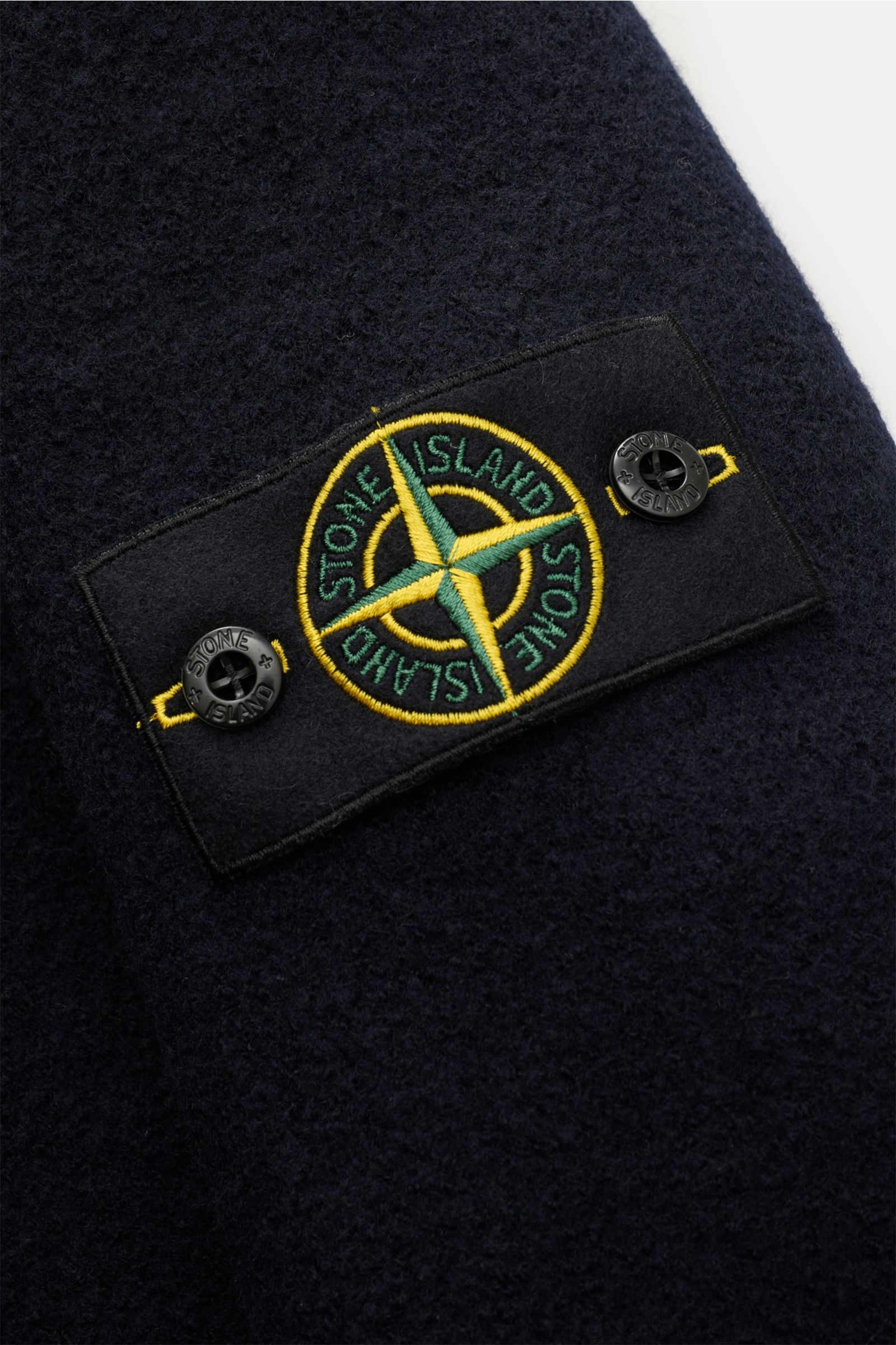 Nahaufnahme der Stone Island Cabanjacke navy aus reiner, gefilzter Wolle mit weichem Griff, garment dyed, typischem Kompass-Badge am Ärmel.