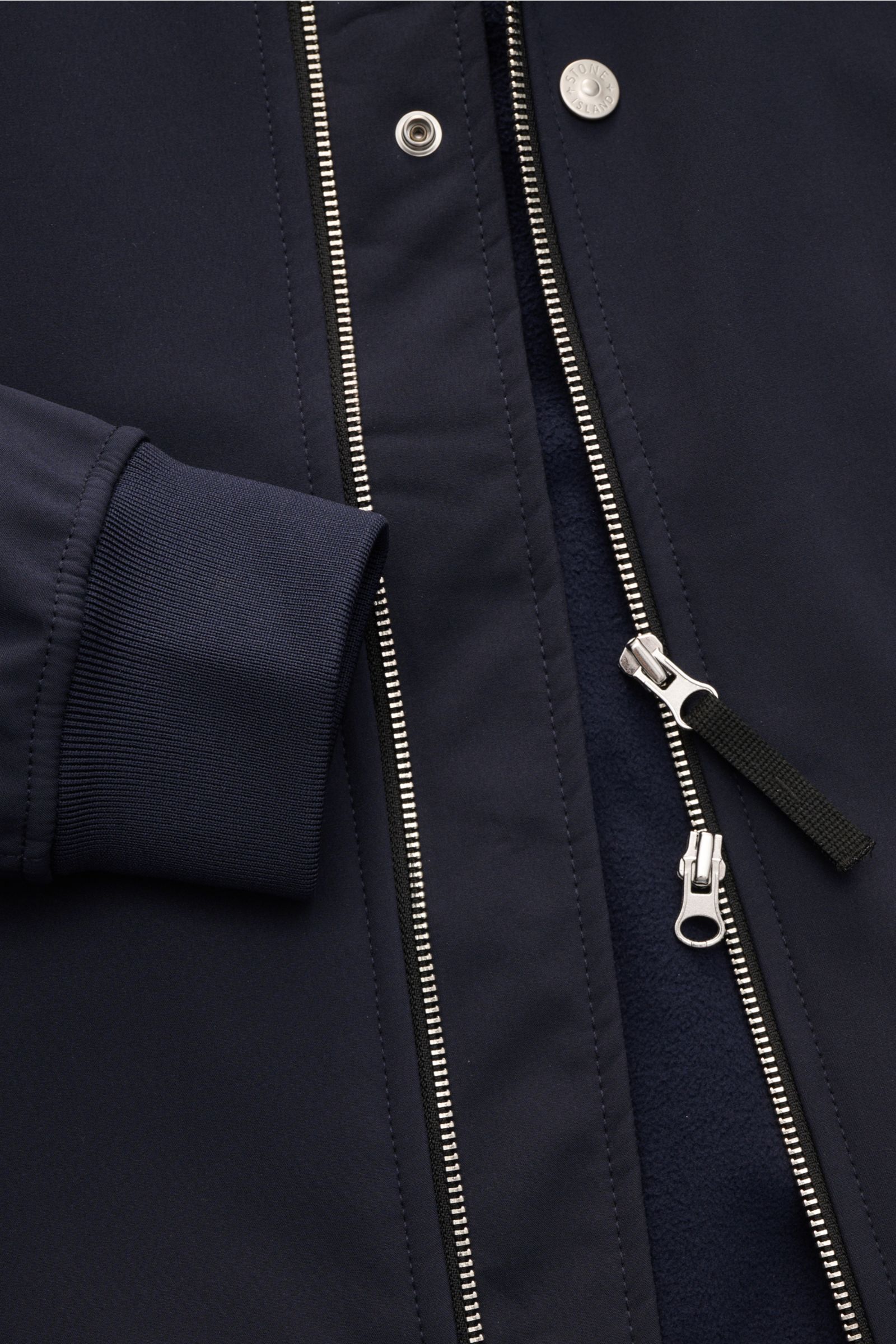 Close-up front view of Stone Island Softshell-Blouson 'Light Soft Shell-R e.dye Technology' navy showing elastic microfiber cuff, two-way zipper, and snap button.

Description: Ob für sportliche Aktivitäten oder als Casual-Allrounder, auf die wind- und