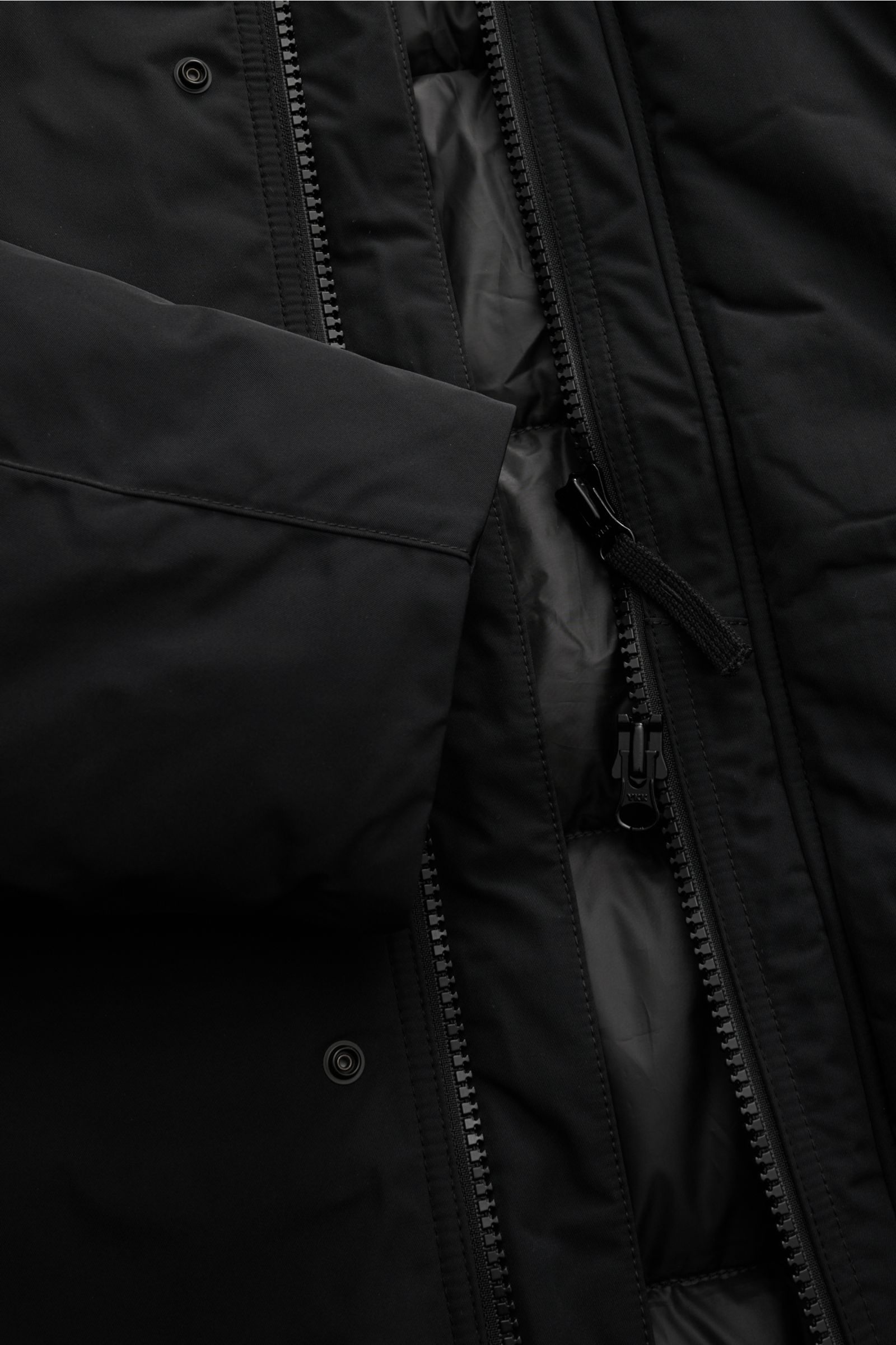 Nahaufnahme des Stone Island Daunenparka 'Micro Twill Down' schwarz, zeigt Reißverschluss, wasserabweisendes Twill-Material und Daunenfüllung.