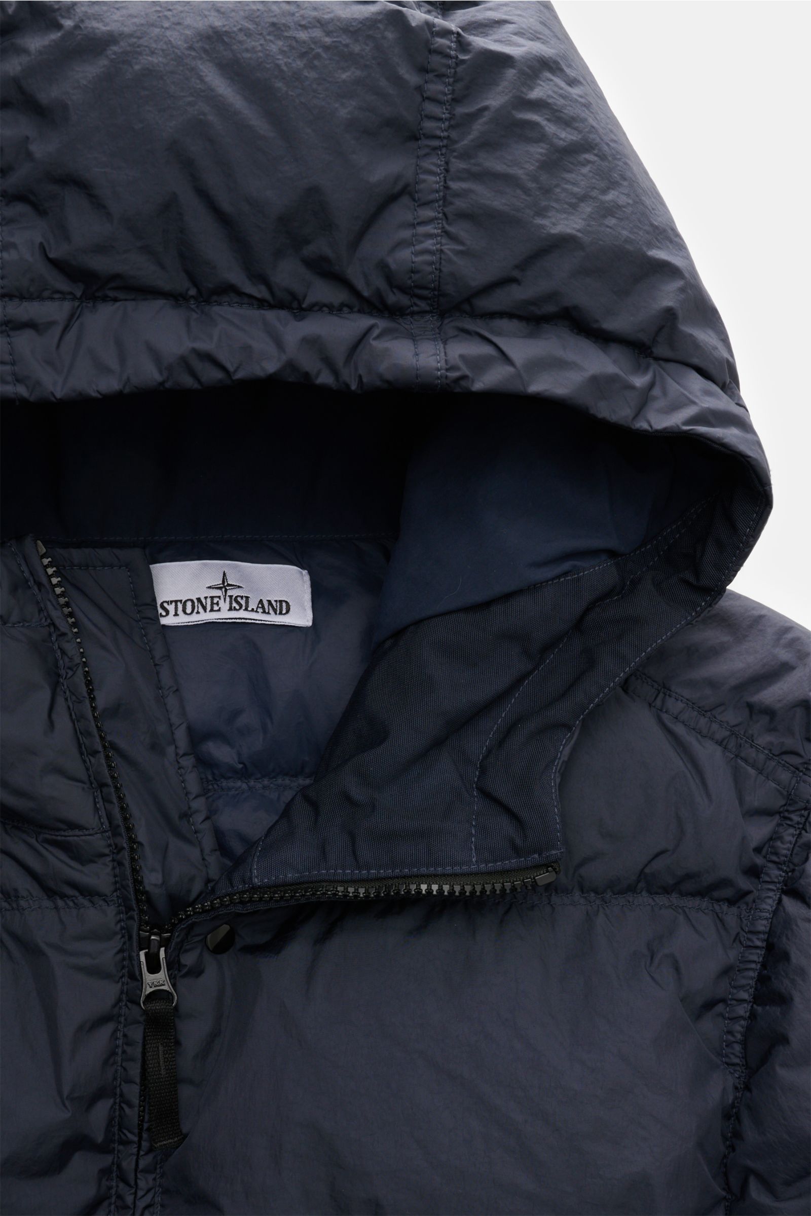 Close-up front view of Stone Island Daunenjacke 'Garment Dyed Crinkle Reps NY' navy with hood, zipper, and label visible, showing crinkle microfiber.

Description: Bei der Daunenjacke 'Garment Dyed Crinkle Reps NY' von STONE ISLAND trifft beschichtete 