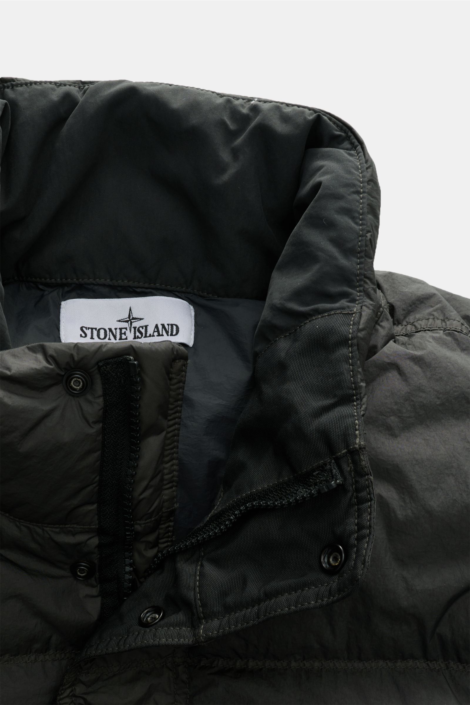 Stone Island Daunenjacke 'Garment Dyed Crinkle Reps NY' dunkelgrau shown close-up from above, highlighting collar, zipper, snap buttons, and inner label; features crinkle microfiber, windproof, water-resistant, warm down fill, garment dyed, regular fit, t