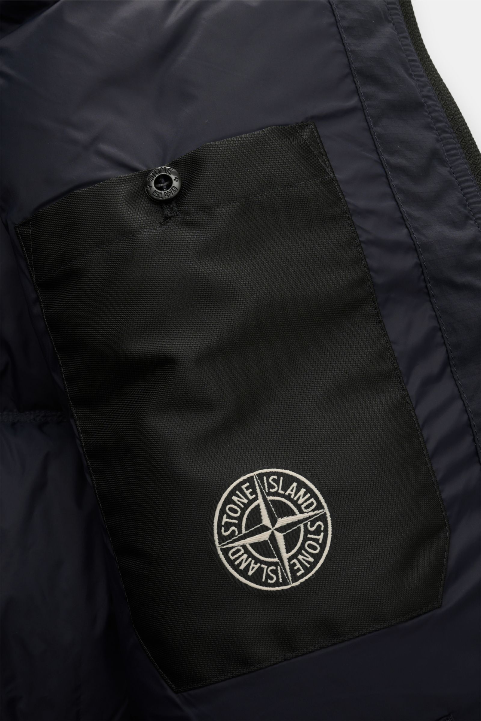 Innenansicht der Stone Island Daunenjacke 'Matt Ripstop Cordura' navy mit schwarzer Innentasche aus hochwertiger Microfaser, wasserabweisend, Slim Fit, wärmender Daunenfüllung, Zwei-Wege-Reißverschluss, Kapuze, regulierbarem Saum und Ärmelbündchen.