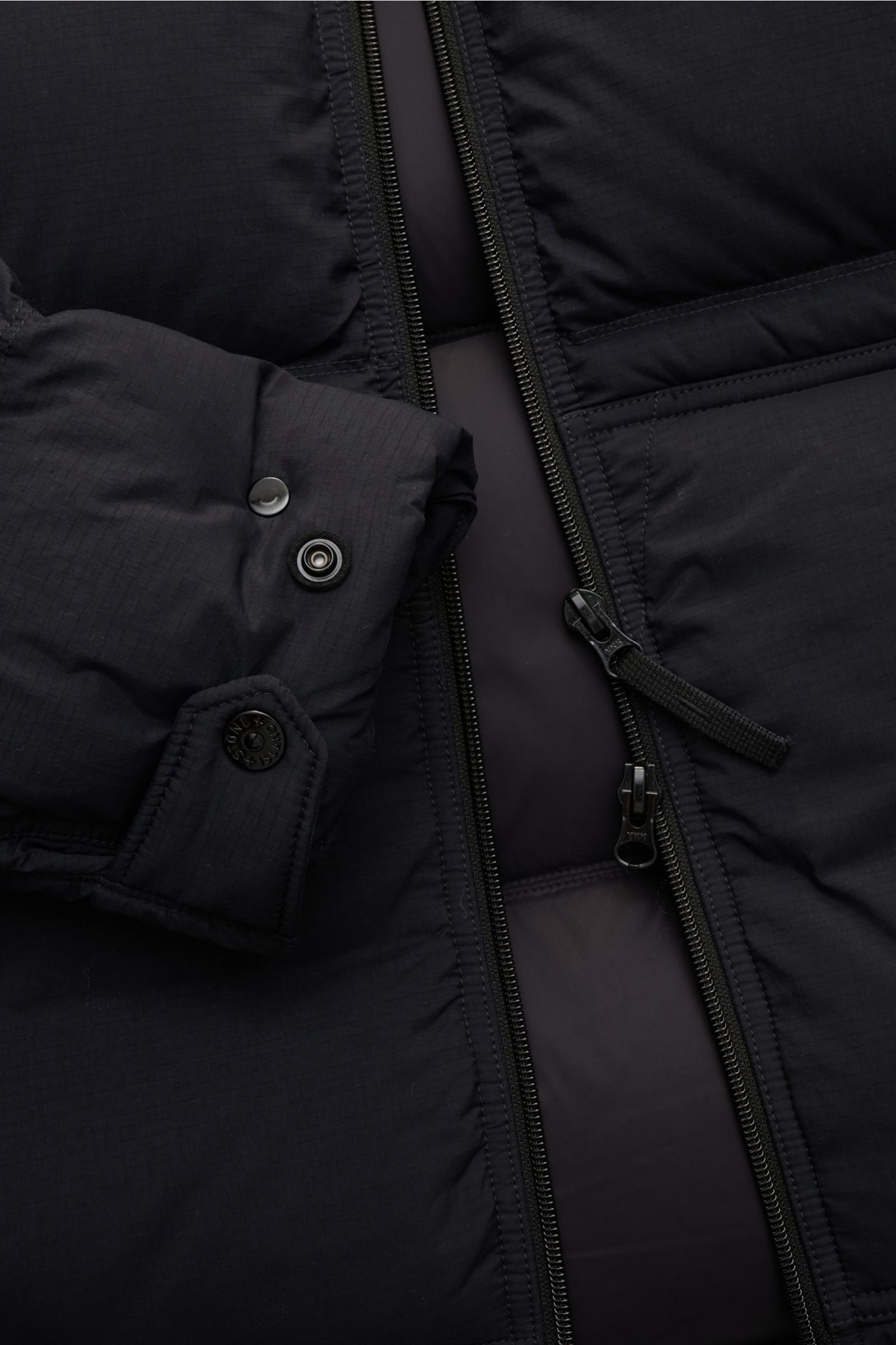 Close-up front view of Stone Island Daunenjacke 'Matt Ripstop Cordura' navy, showing detailed zipper and cuff with snap buttons; high-quality microfibre, soft touch, wind- and water-repellent ripstop material with warm down filling.