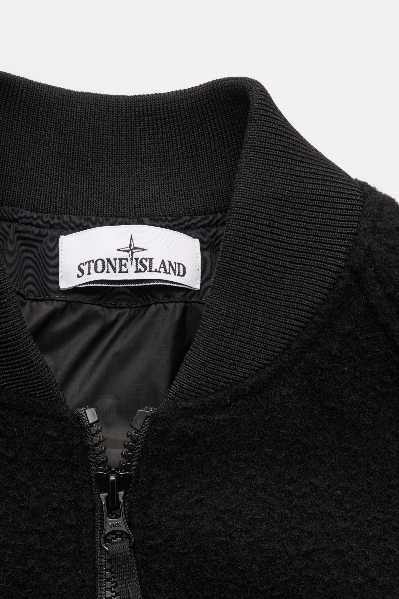 Close-up front view of Stone Island Blouson 'Panno Ratinato' schwarz showing ribbed collar, two-way zipper, and textured wool-mix fabric. Monochrome Herbst-Looks: Der Blouson 'Panno Ratinato' von STONE ISLAND wird mit seinem sportiven Design und dem Struk
