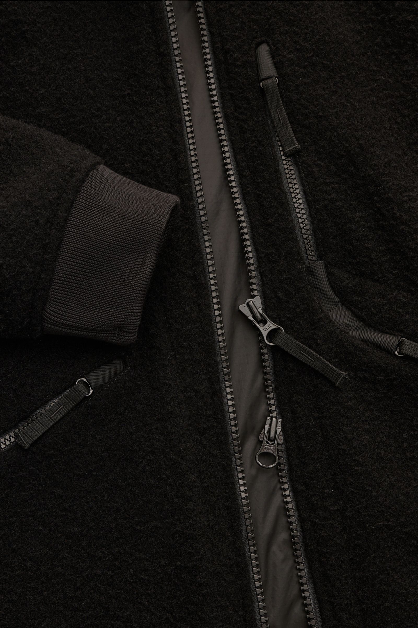 Close-up front view of Stone Island Jacket 'Panno Ratinato' black showing its ratiné wool-microfibre blend fabric, two-way zipper, zip front pockets, ribbed cuff, and detailed stitching.

Functional and eye-catching: This STONE ISLAND hooded jacket is 
