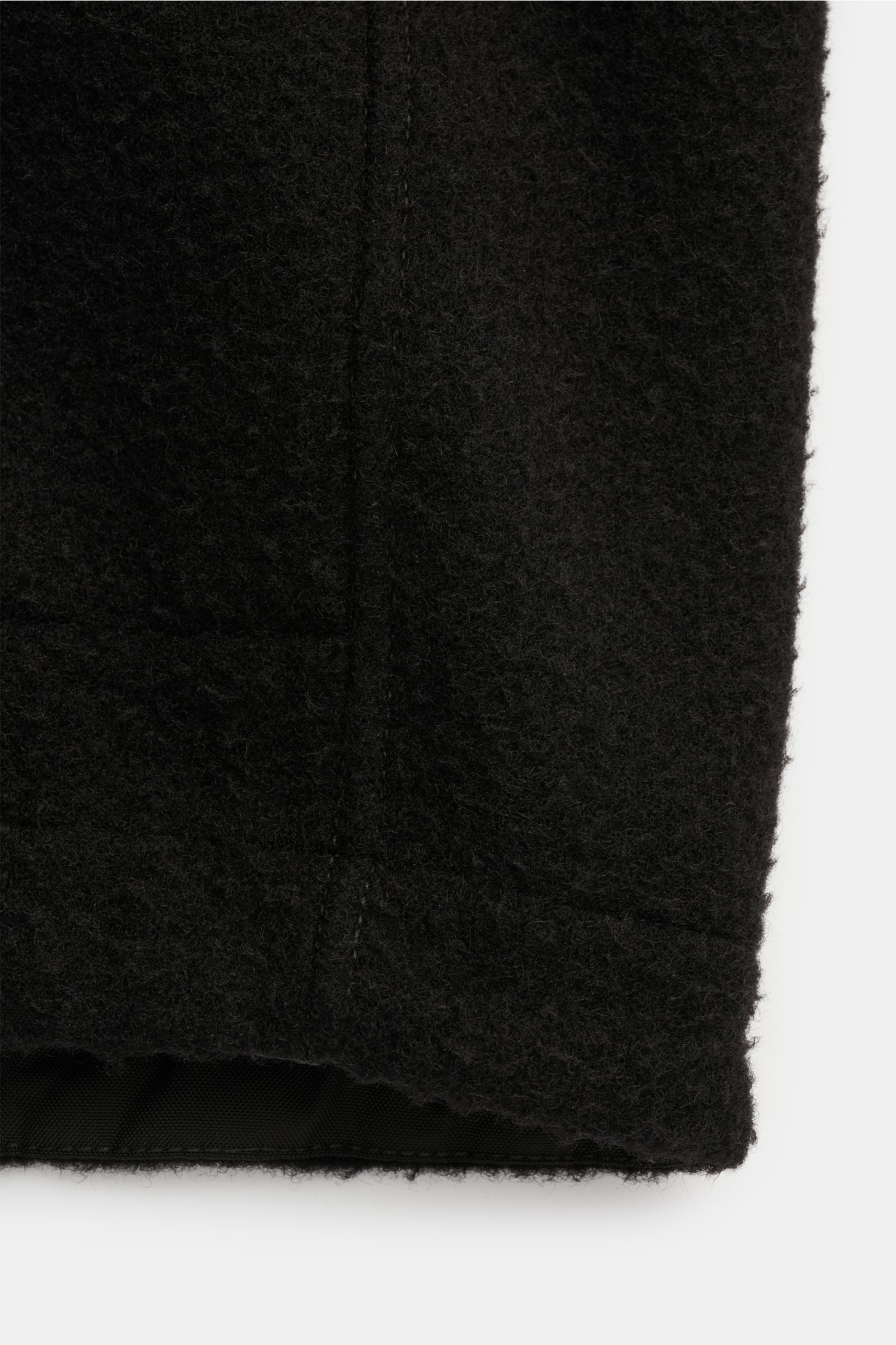 Close-up front view of the lower hem of the black Stone Island Jacket 'Panno Ratinato' showing its ratiné wool blend texture and smooth lining.

Description (incorporated content):
Functional and eye-catching: This STONE ISLAND hooded jacket is an eye-cat