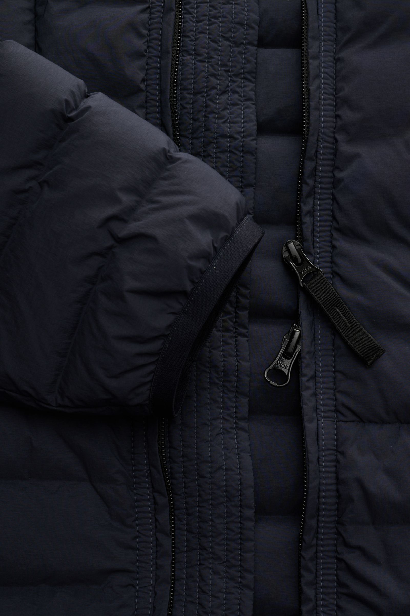 Stone Island Daunenjacke 'Seamless Tunnel Nylon Down-TC' navy in Nahaufnahme von vorne mit Zwei-Wege-Reißverschluss, elastischem Ärmelabschluss und glattem Griff.