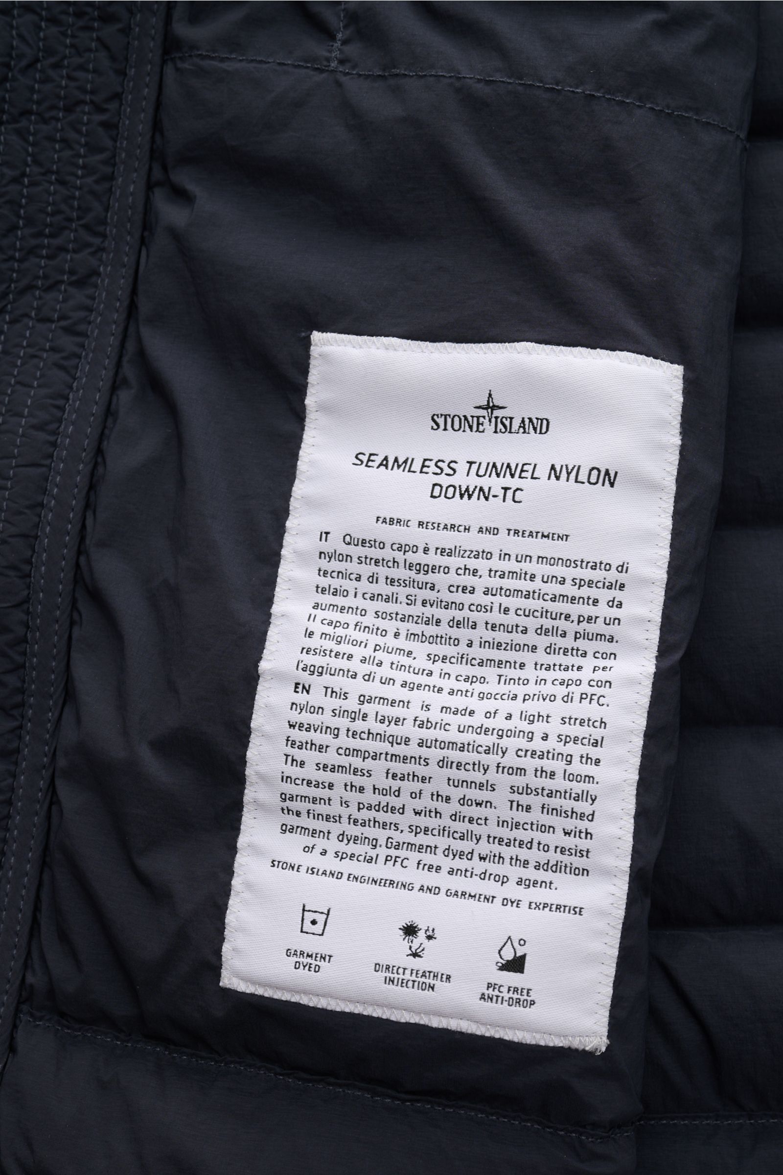 Stone Island Daunenjacke 'Seamless Tunnel Nylon Down-TC' navy, Innenansicht mit Nahtloser Nylon-Microfaser, leichter Daunenfüllung, Pflegeetikett sichtbar.