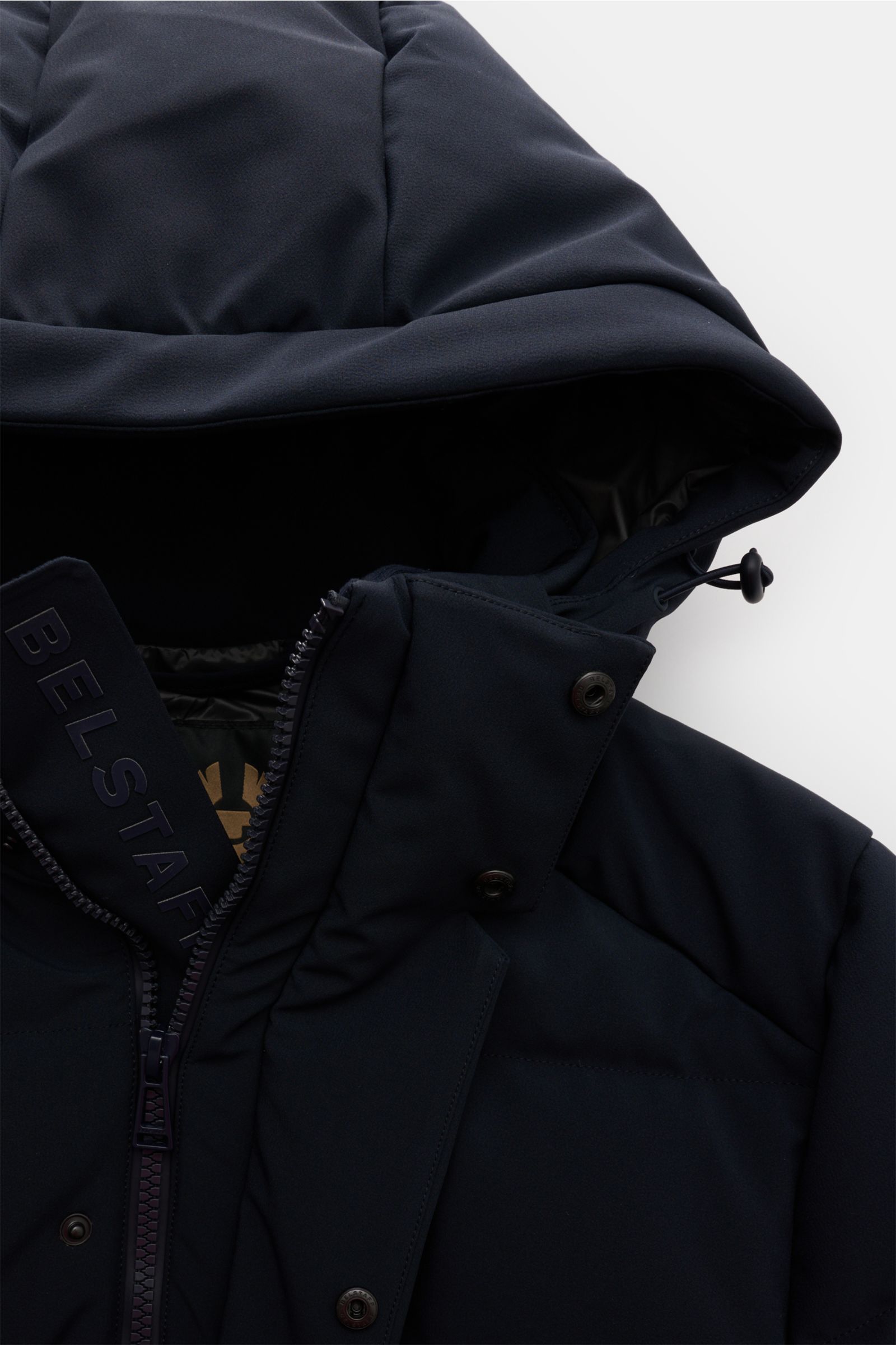 Nahaufnahme der Belstaff Daunenjacke 'Pendulum' navy von oben, zeigt abnehmbare Kapuze mit Tunnelzug, robusten Zwei-Wege-Reißverschluss, wind- und wasserabweisende Microfaser und wärmende Daunenfüllung.
