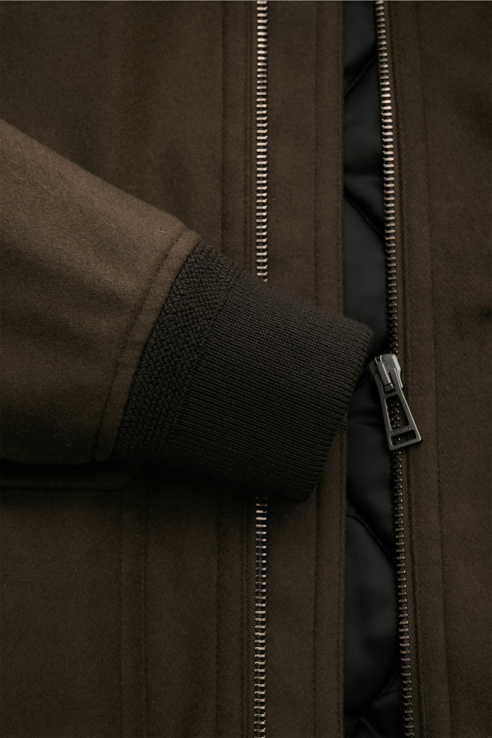 Nahaufnahme des Reißverschlusses und des elastischen Ärmelbündchens des Belstaff Blouson 'Welder Jacket' braun mit gestepptem Futter.
