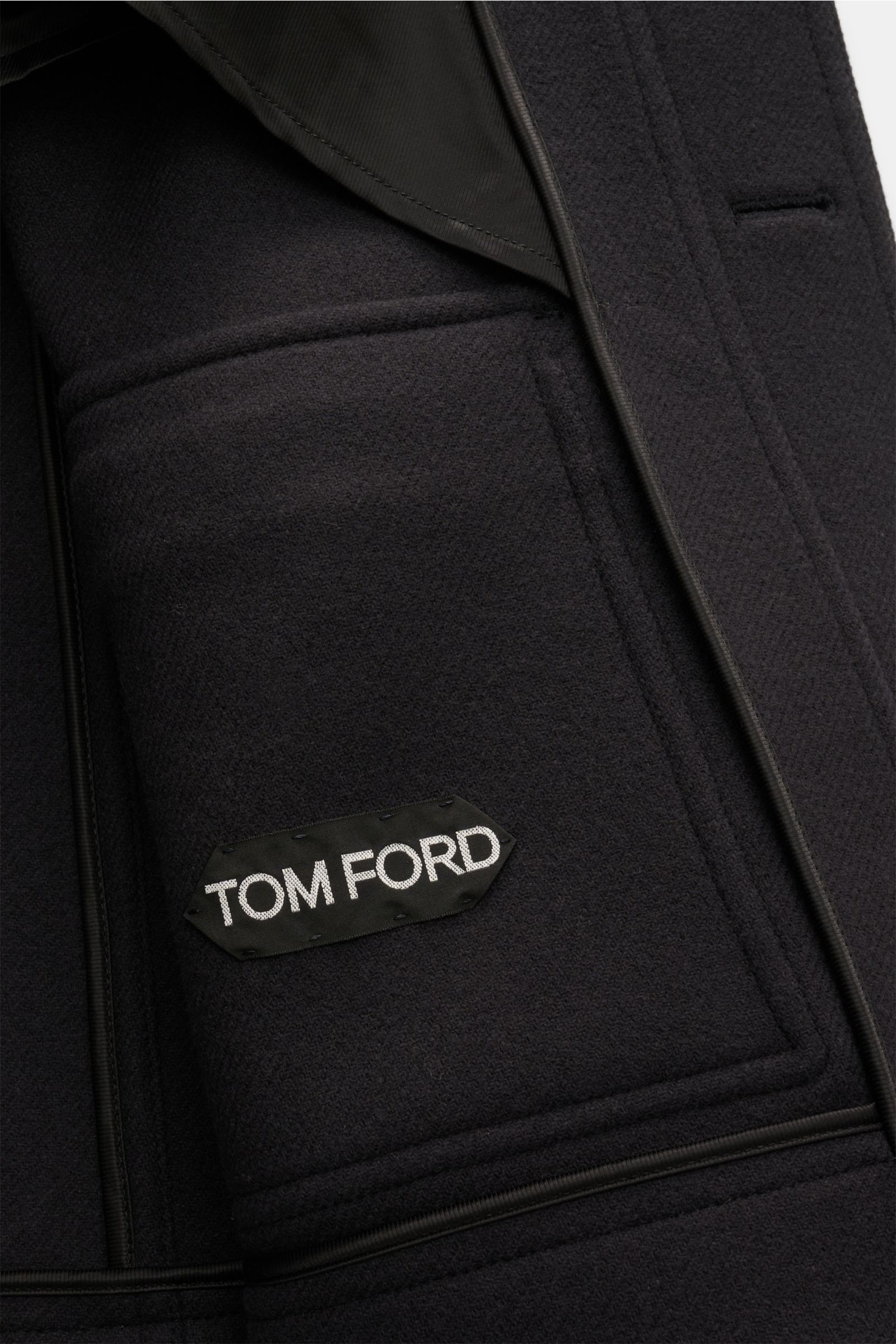 Close-up interior view of the Tom Ford Wool jacket navy, showing the black Tom Ford label on pure virgin wool fabric.

With its clean lines and distinctive flap pockets, this wool jacket by TOM FORD combines timeless utility elements with urban eleganc