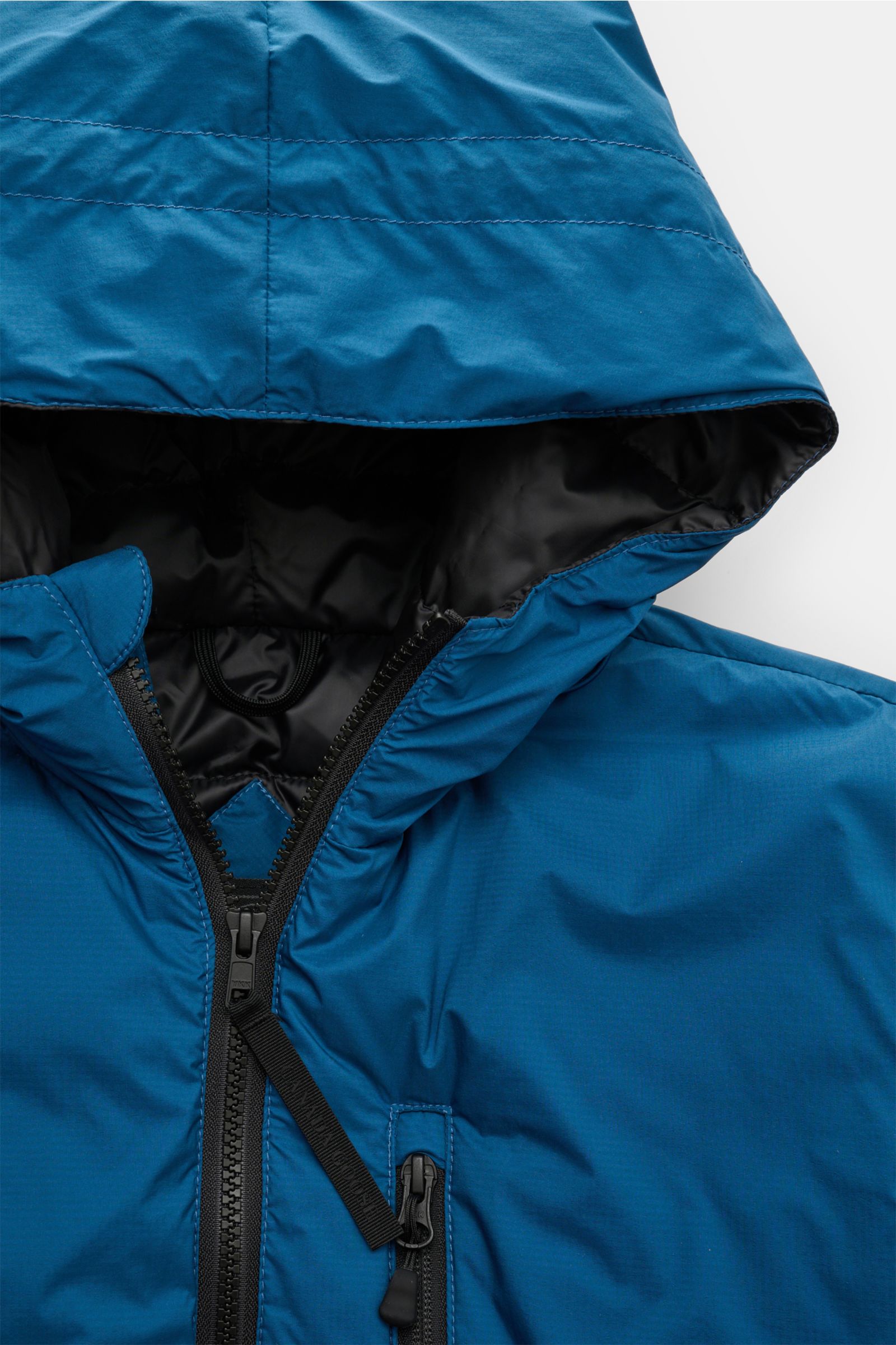 Close-up front view of Canada Goose Down jacket 'Lodge Hoody' blue with padded hood, two-way zip, and zippered breast pocket.

Description: Maximum comfort in a lightweight design: A padded hood and a down lining make the self-stowing down jacket 'Lodg