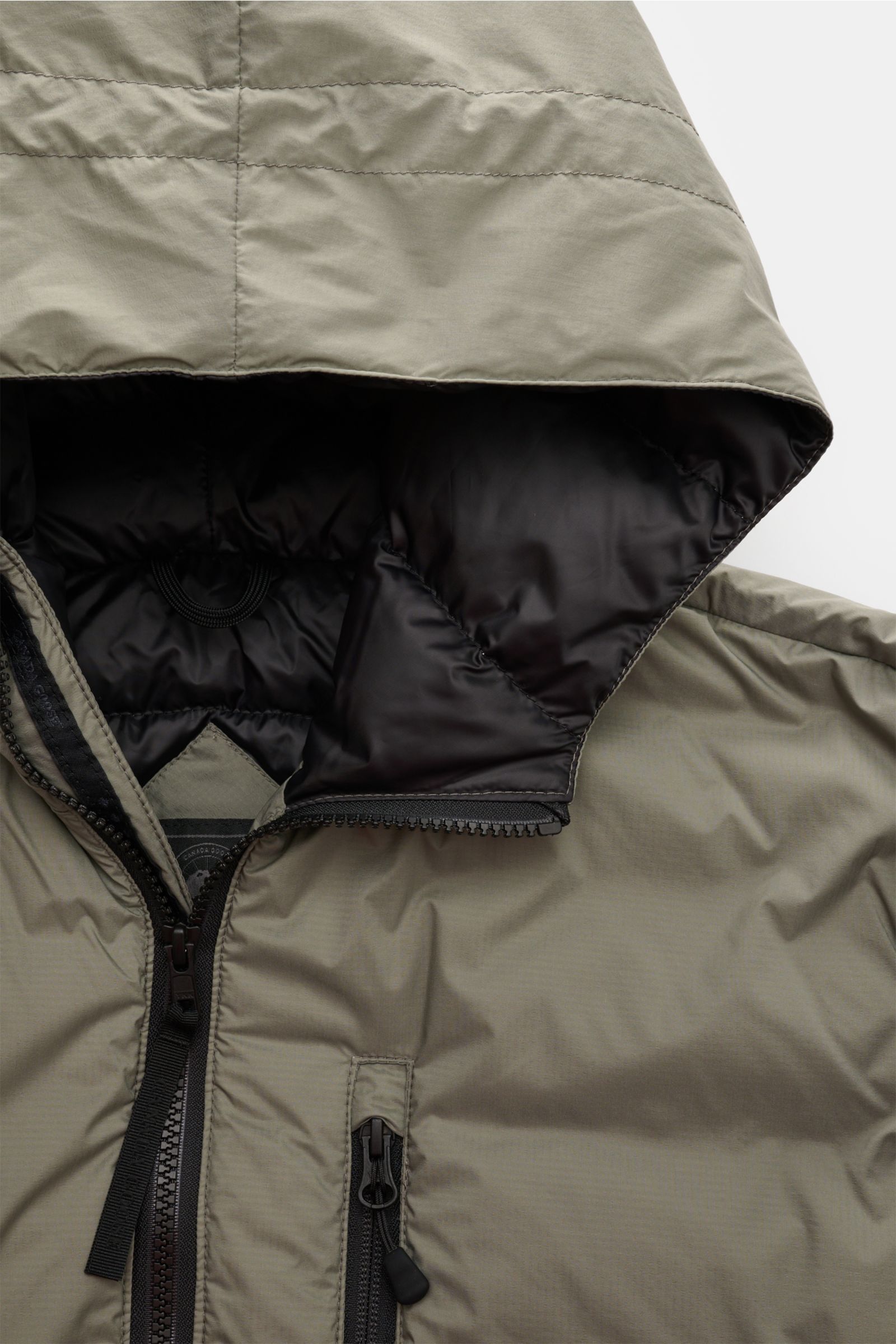 Canada Goose Daunenjacke 'Lodge Hoody' graugrün aus Ripstop-Microfaser, wattierte Kapuze, Reißverschluss, Brusttasche, Innenfutter, Nahaufnahme von oben.