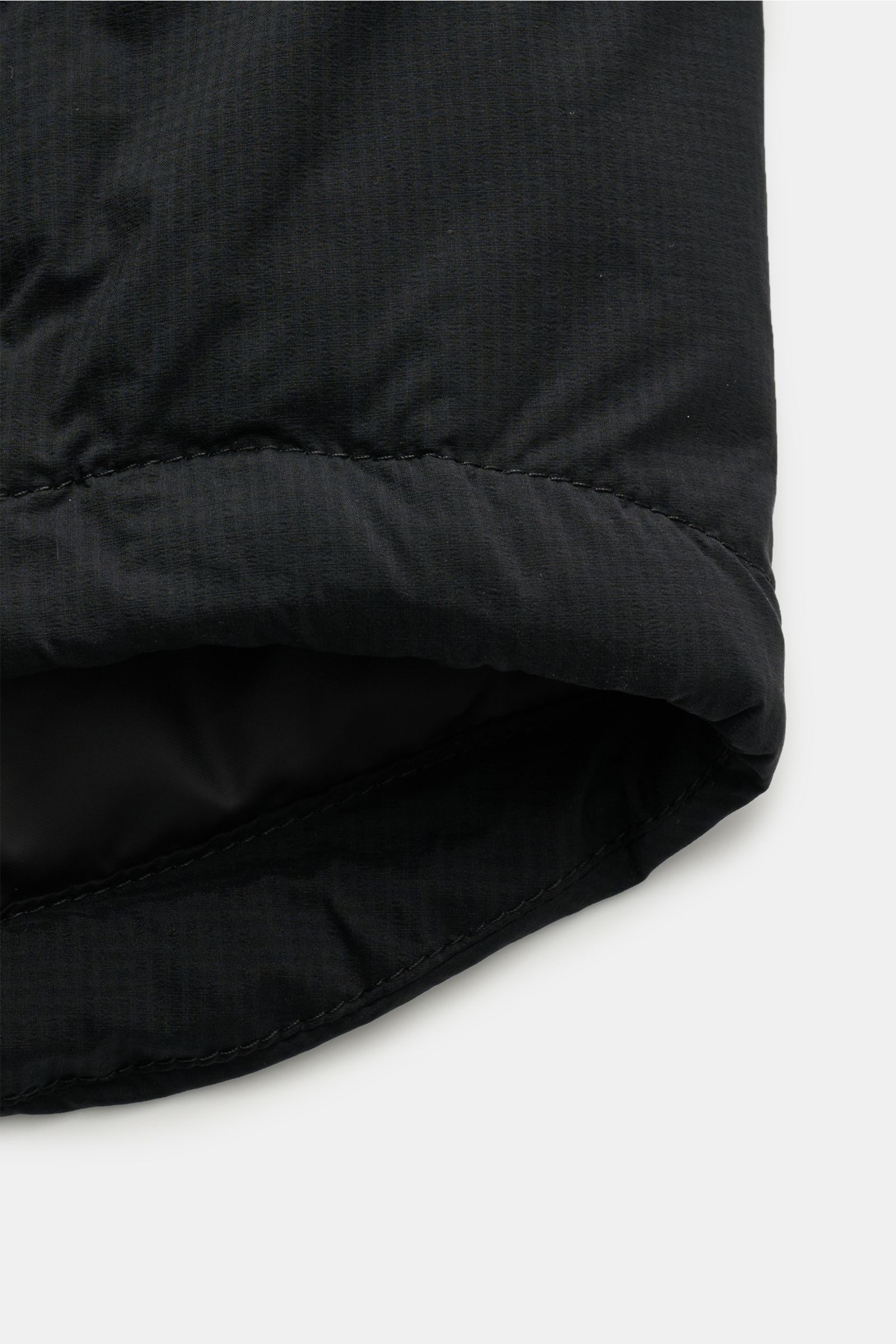 Schwarzer Saum der Canada Goose Daunenjacke 'Lodge Hoody' schwarz, Detailaufnahme von unten, Ripstop-Gewebe, gesteppter Futterstoff, verstellbare Saumweite.