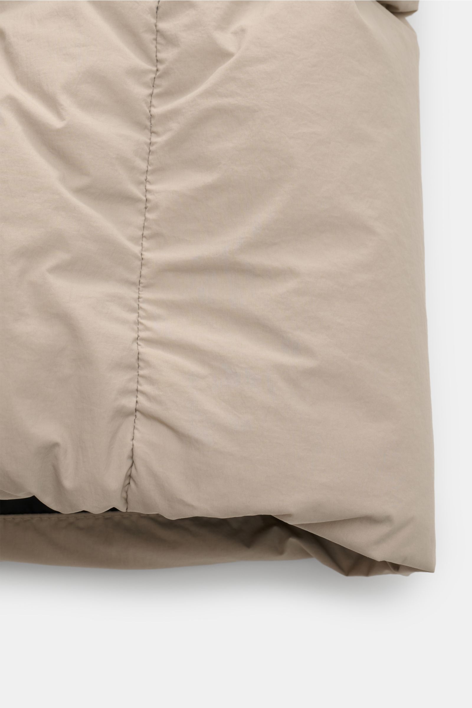 Nahaufnahme der sandfarbenen Canada Goose Daunenjacke 'Crofton Puffer' von unten, zeigt voluminöse Daunenfüllung und glatten Microfaser-Popeline.