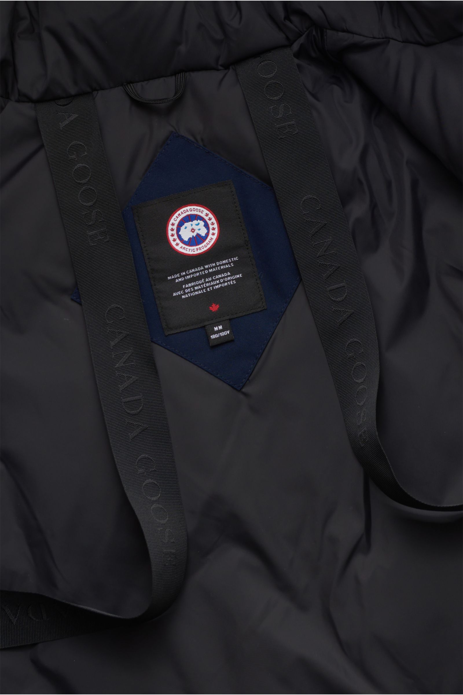 Detailaufnahme des Canada Goose Daunenparka 'Langford' navy von innen mit Arctic-Tech-Material, Rucksackriemen und Markenlabel.