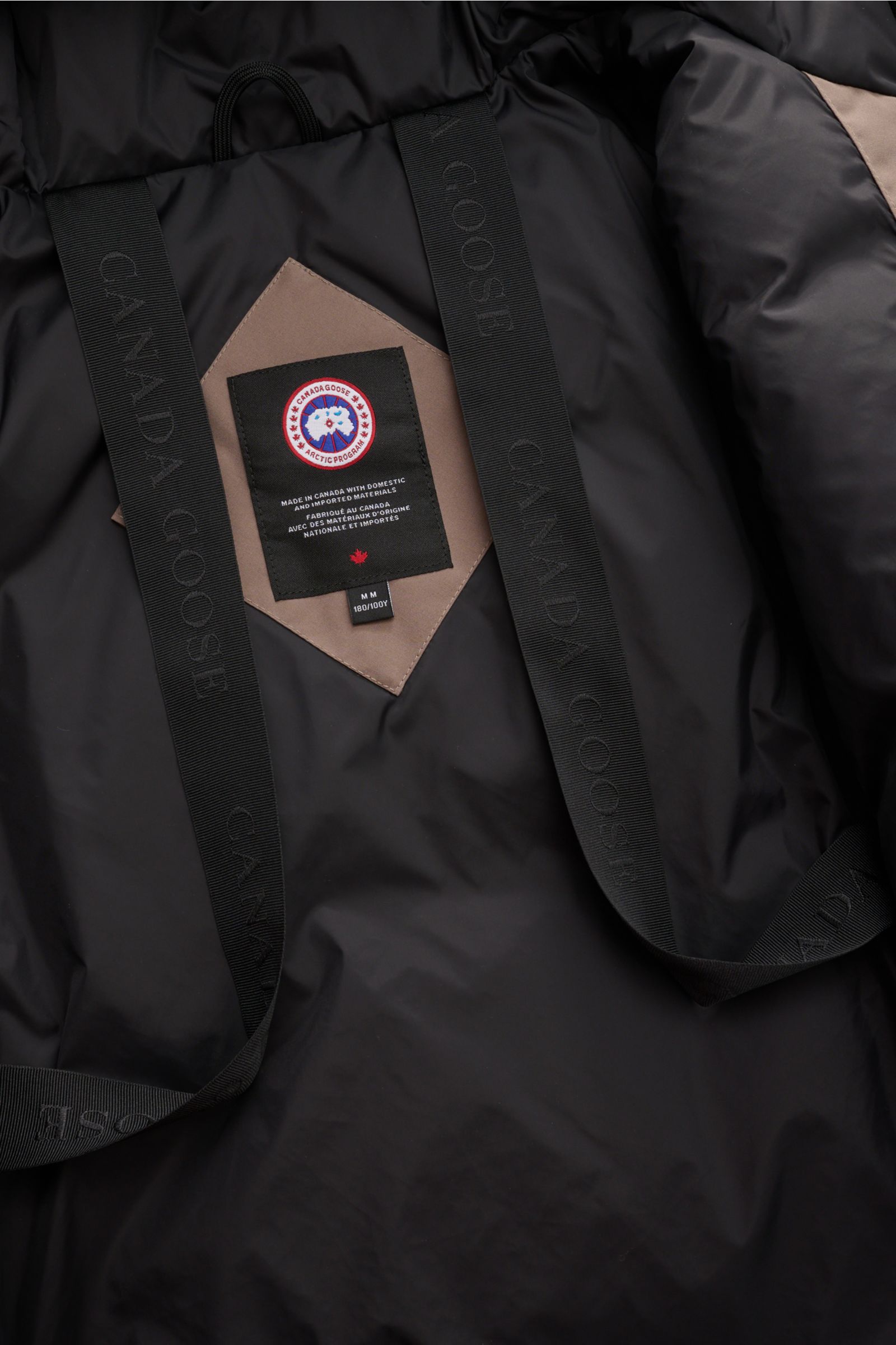 Canada Goose Daunenparka 'Langford' taupe von innen, mit Arctic-Tech-Material, Rucksackriemen und tonalem Weblabel, Nahaufnahme.