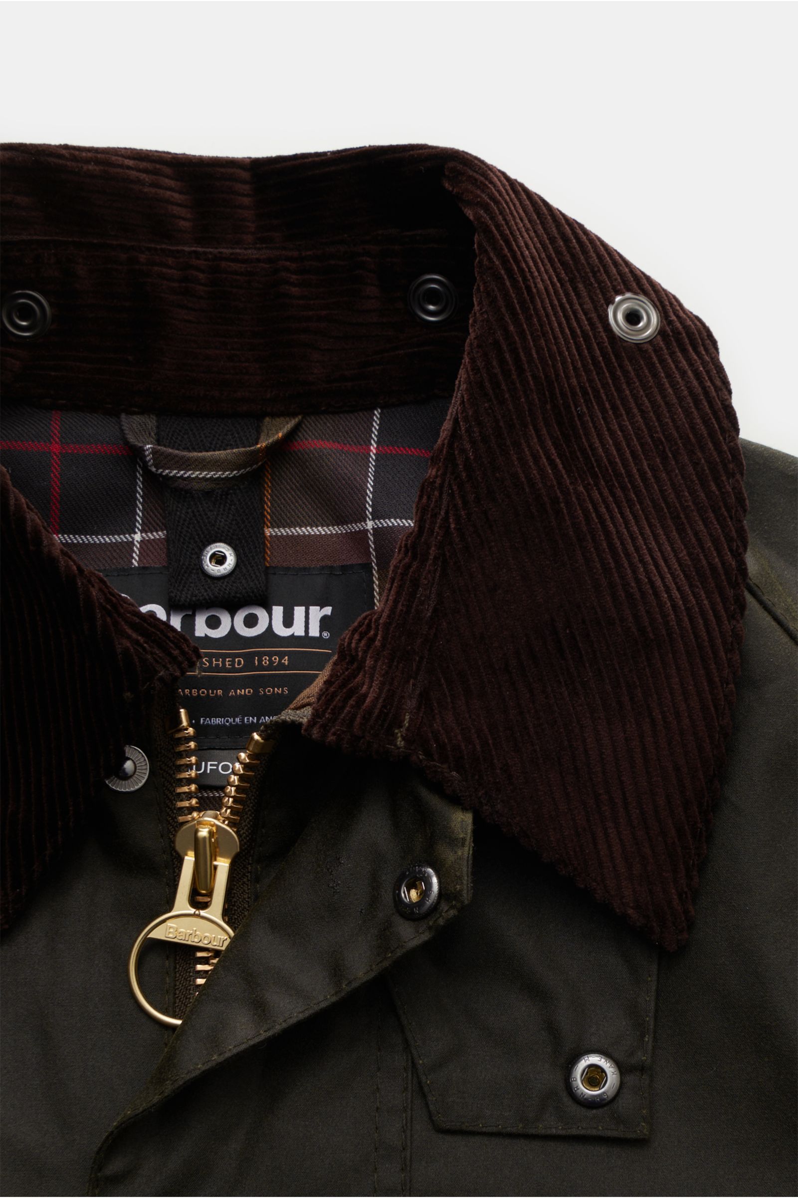 Barbour Waxed jacket 'Beaufort' dark olive shown from a close-up front angle, highlighting the dark brown corduroy collar, gold zipper with ring pull, and classic tartan lining inside. A true classic from BARBOUR: The long waxed jacket 'Beaufort' made of 